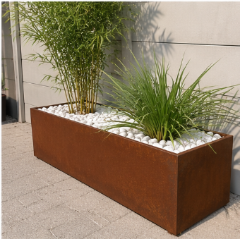 Un grand jardinière rectangulaire en métal rouillé avec des plantes vertes et des pierres blanches décoratives sur le dessus.