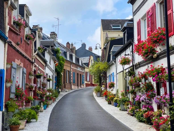 Colorful European street with flower-filled pots and window boxes along the buildings on a sunny day