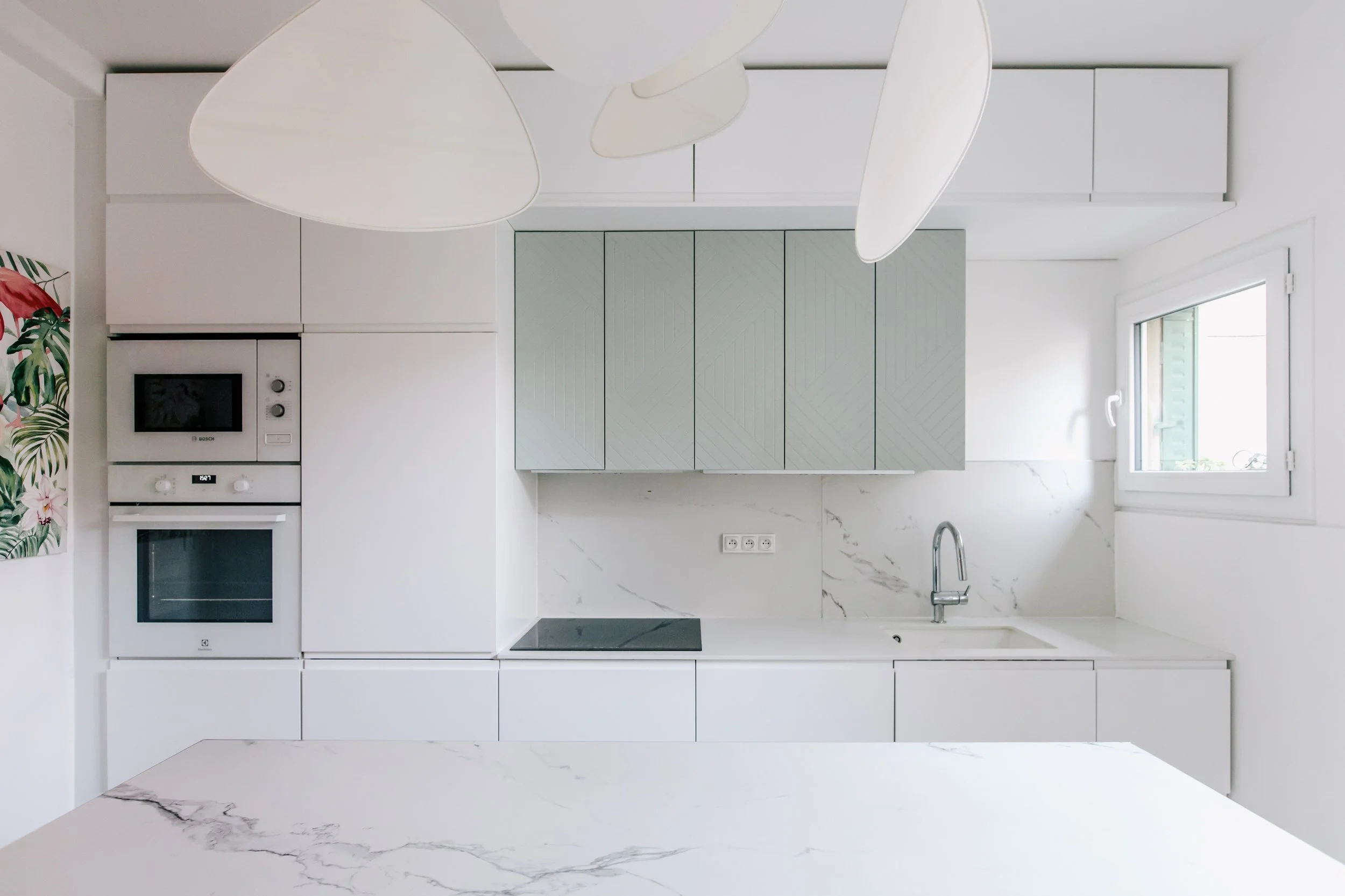 Cuisine minimaliste blanche avec fenêtre et comptoir en marbre blanc