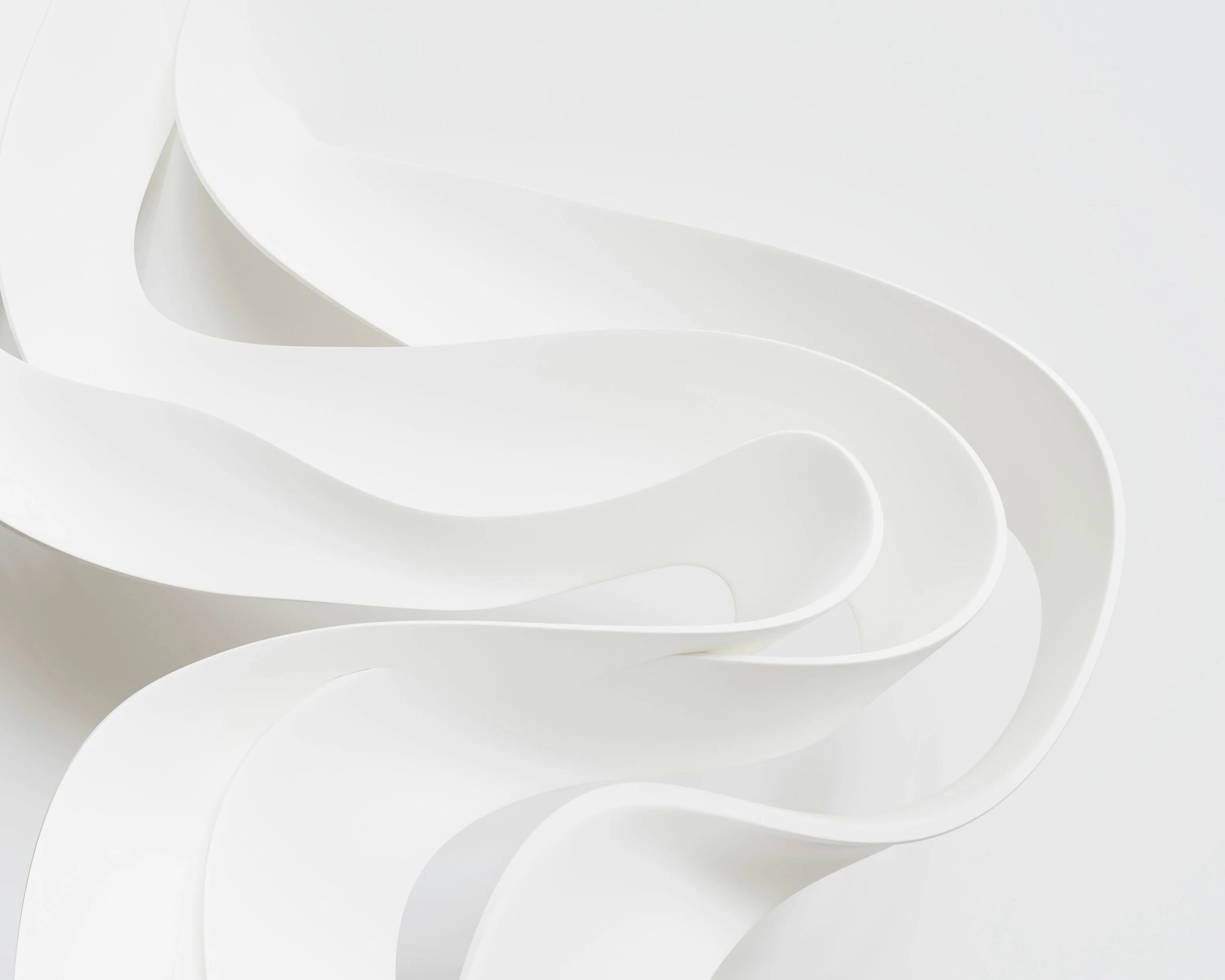 Close-up of white, curved, layered paper or plastic material with smooth edges.
