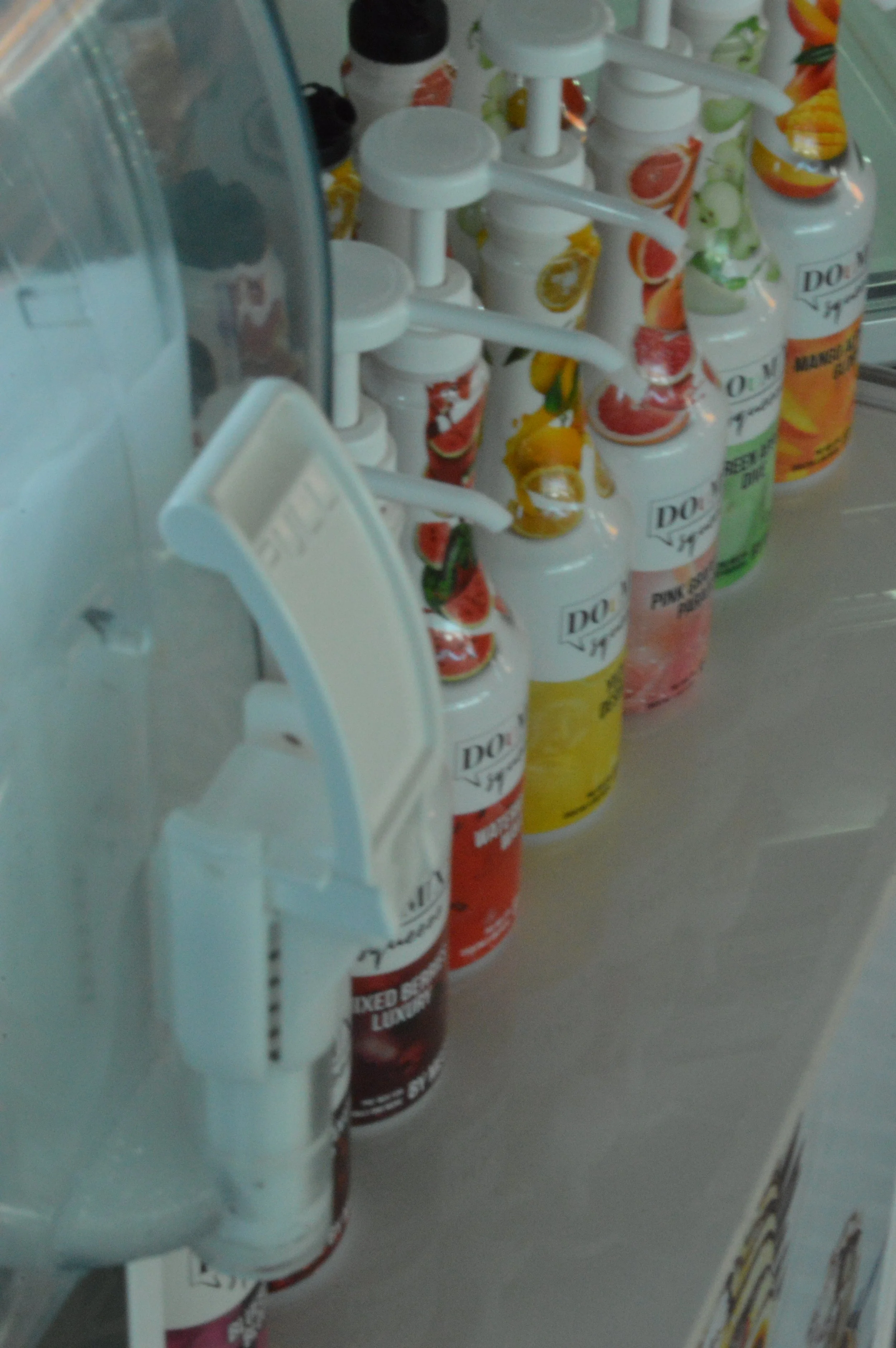 Assorted flavors of Dairy Queen flavored syrup bottles lined up on a counter.