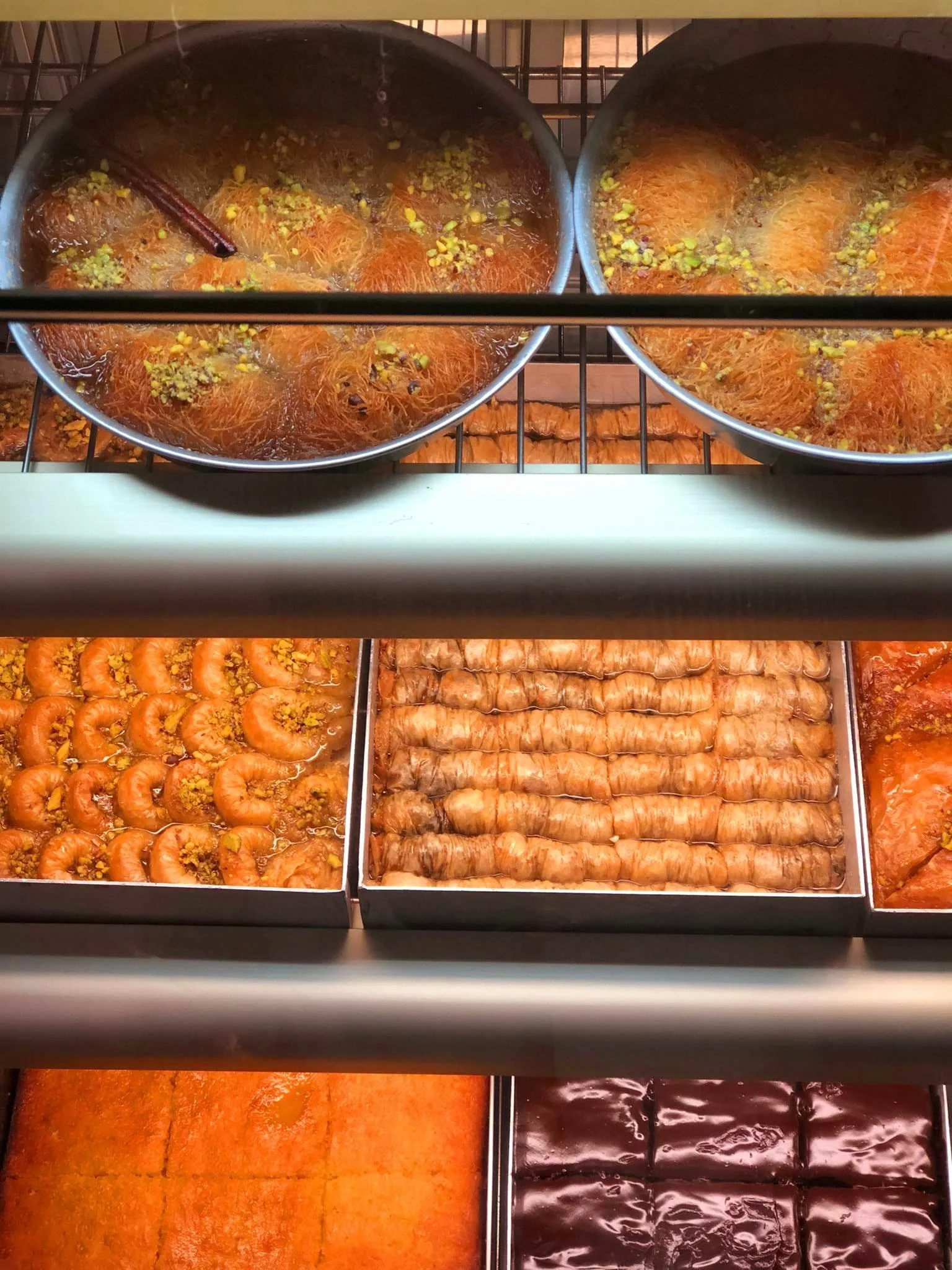 Gelateria Maria - An assortment of Middle Eastern desserts in a display case, including Turkish delight, baklava, imarati, and other sweet treats.