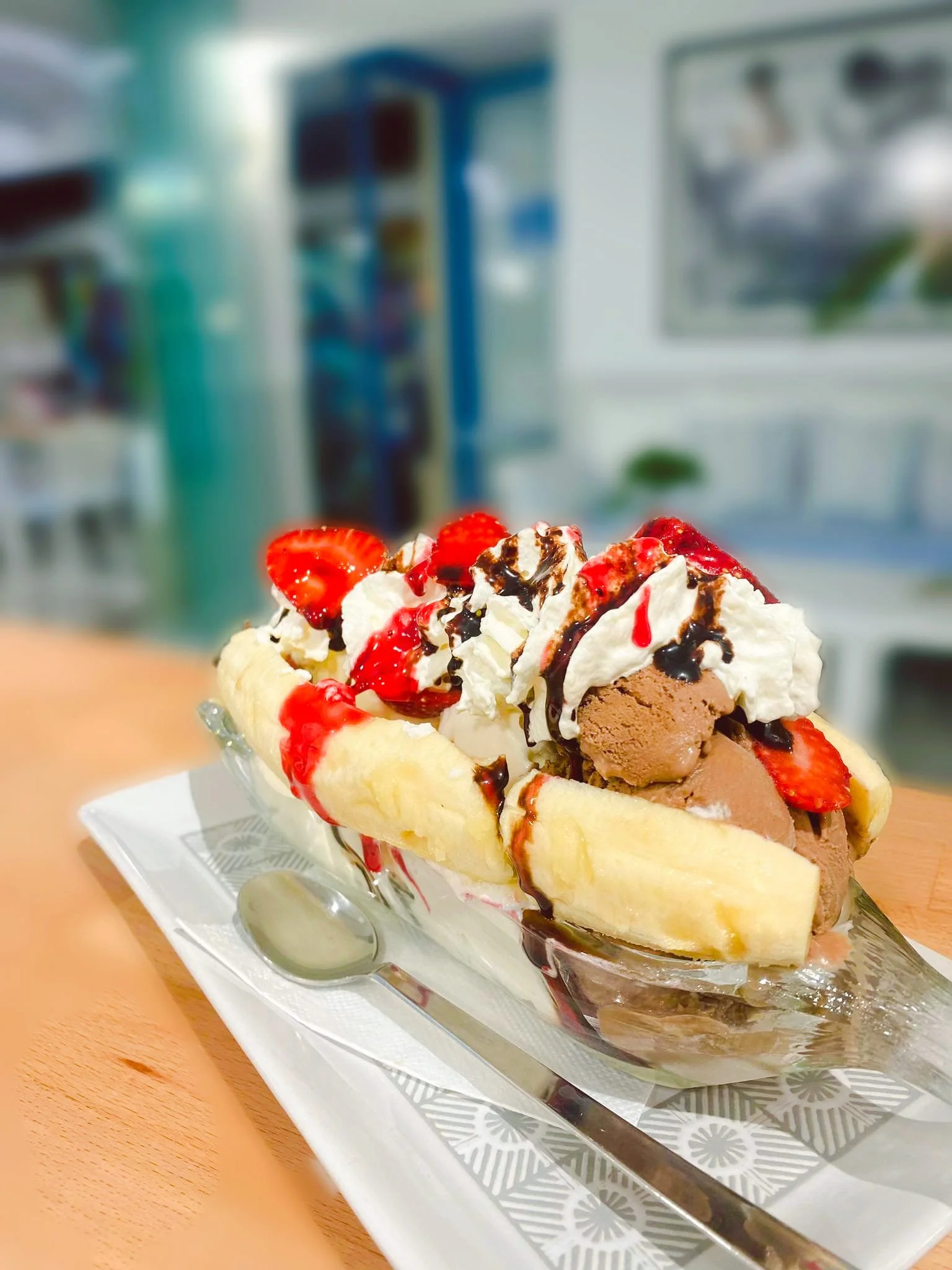 Gelateria Maria - Banana split ice cream topped with strawberries, whipped cream, chocolate syrup, and chocolate ice cream in a glass dish.