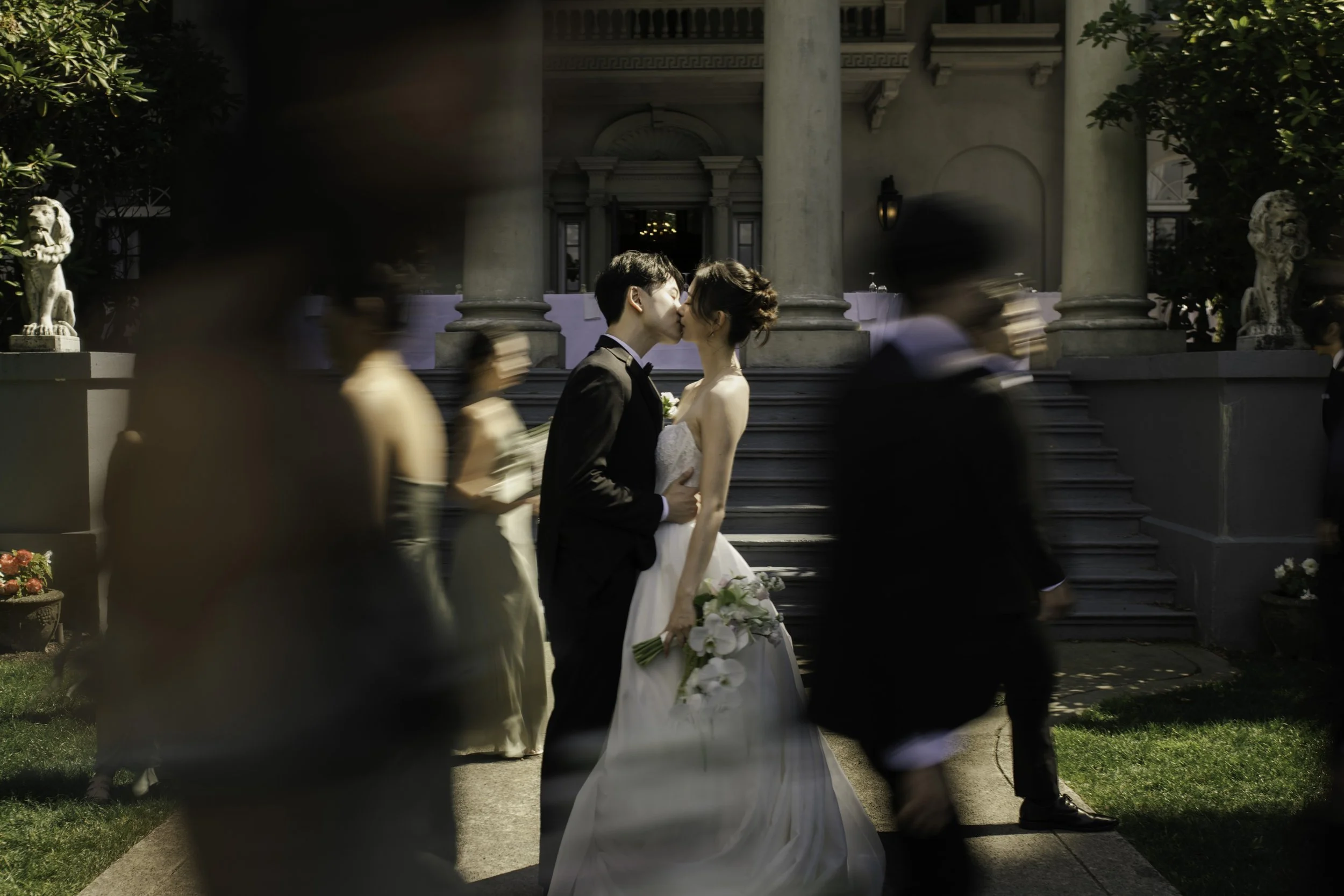 bride and groom kissing in front of their wedding venue