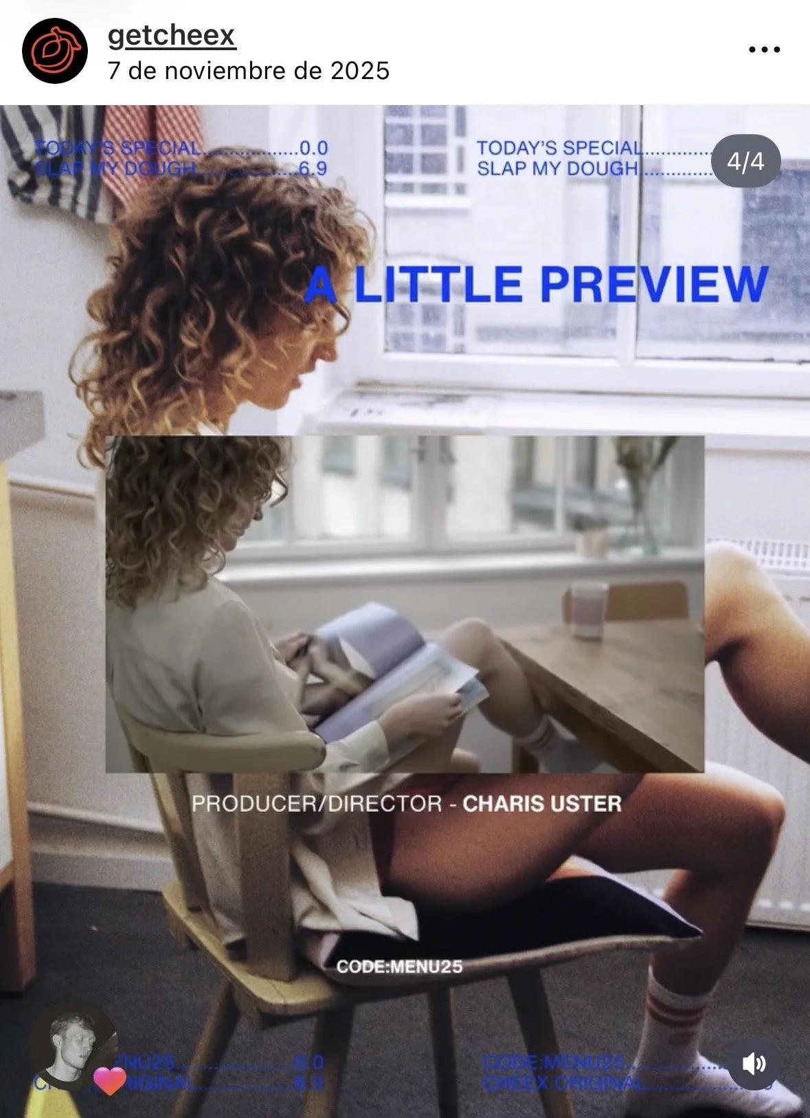 A woman with curly hair reading a book while sitting on a chair by a window in a bright room.
