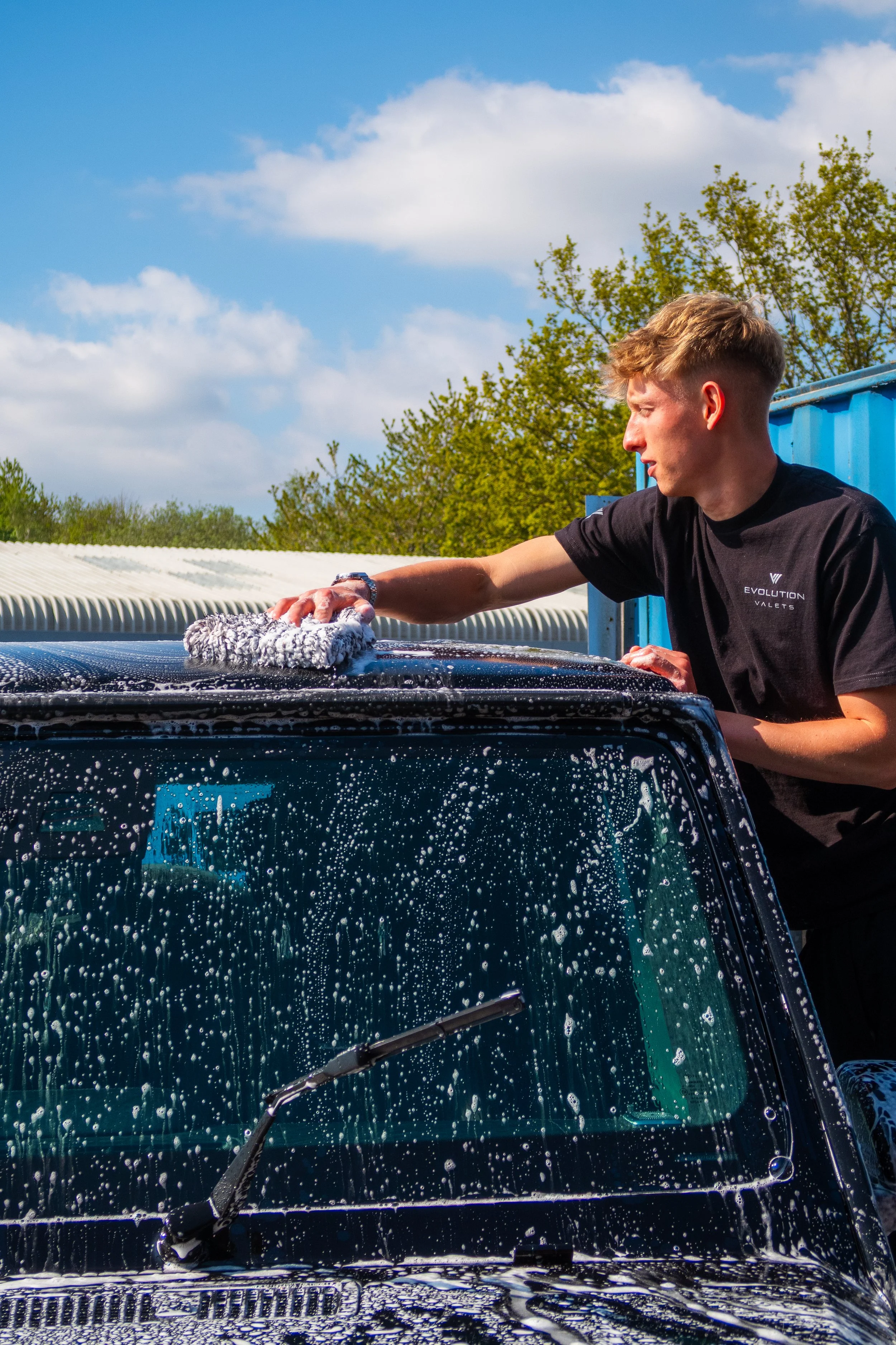Safe hand car wash and premium vehicle valeting service by Evolution Valets in Bristol cleaning a Land Rover Defender exterior professionally