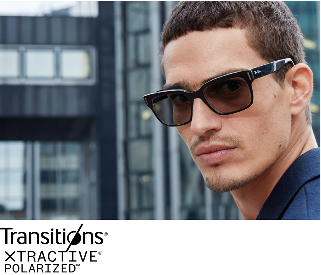 A man wearing black sunglasses with a city office building in the background.