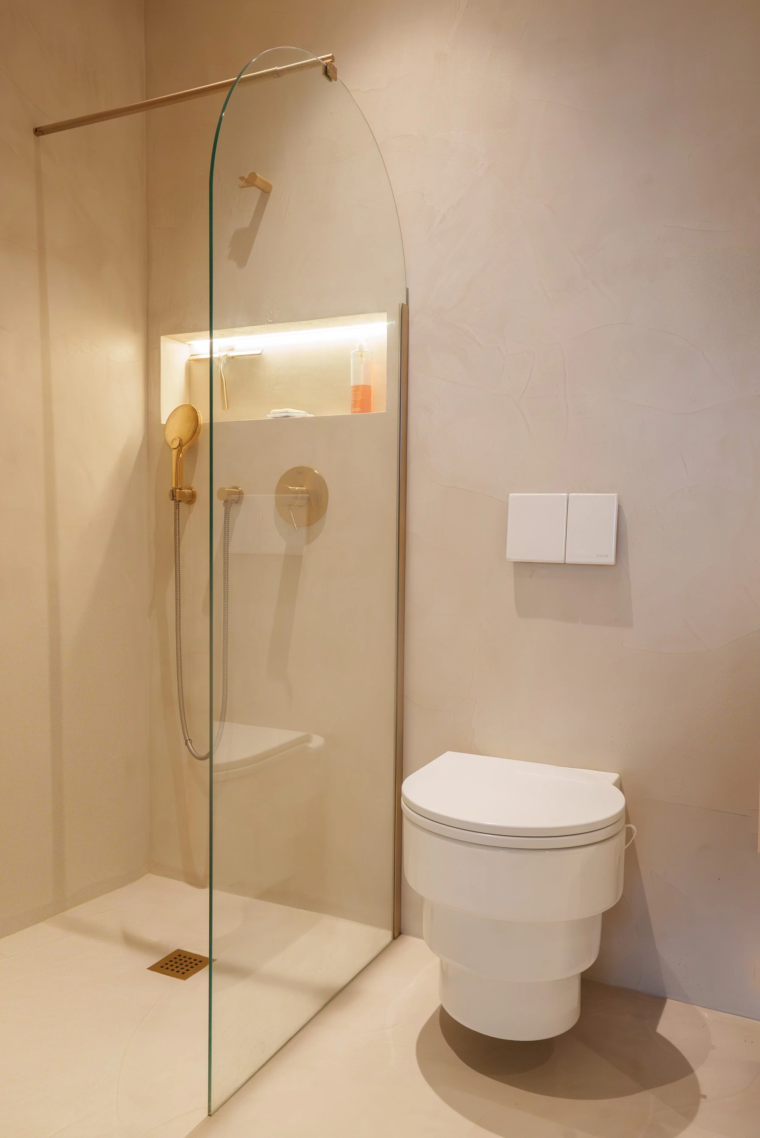 Salle de bain moderne avec douche à l'italienne et toilette suspendue blanche.