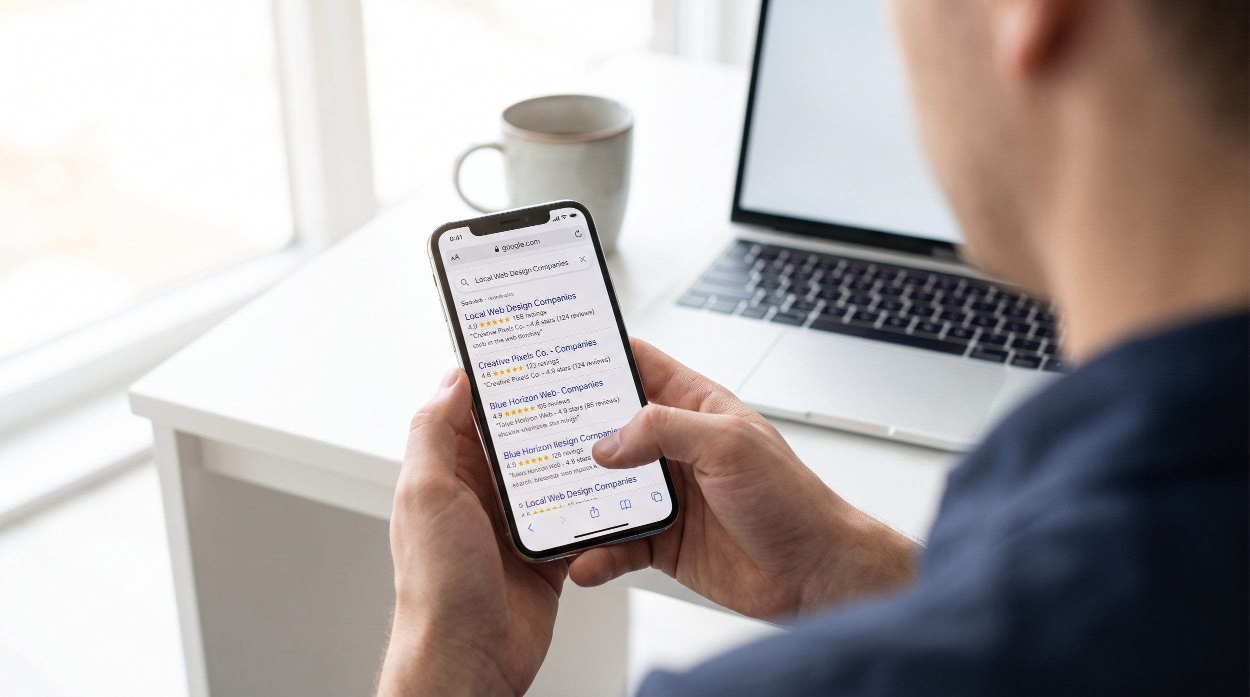 Person checking reviews and search rankings on a phone while researching a web design company