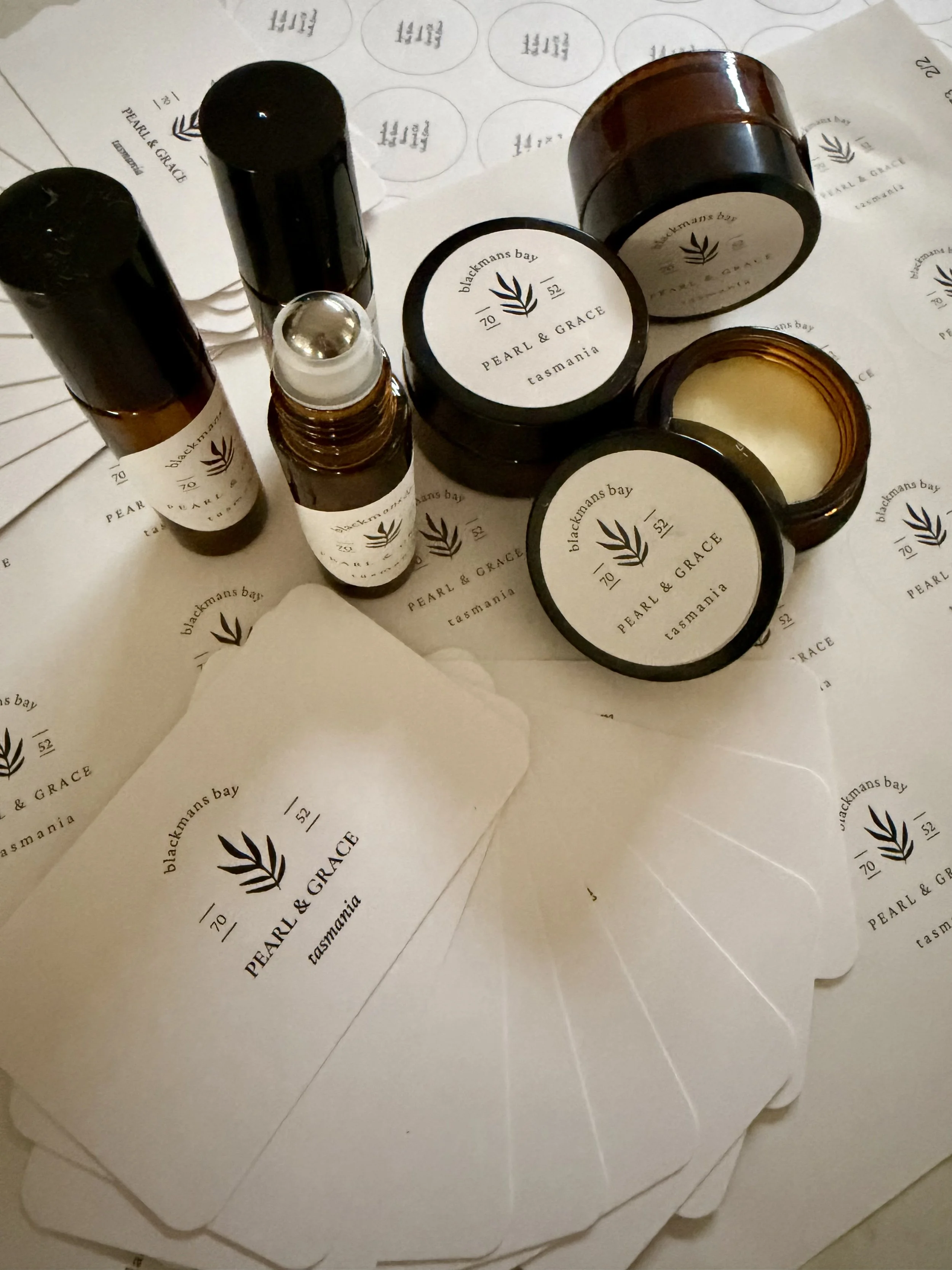 Multiple skincare or cosmetic containers with white labels printed with