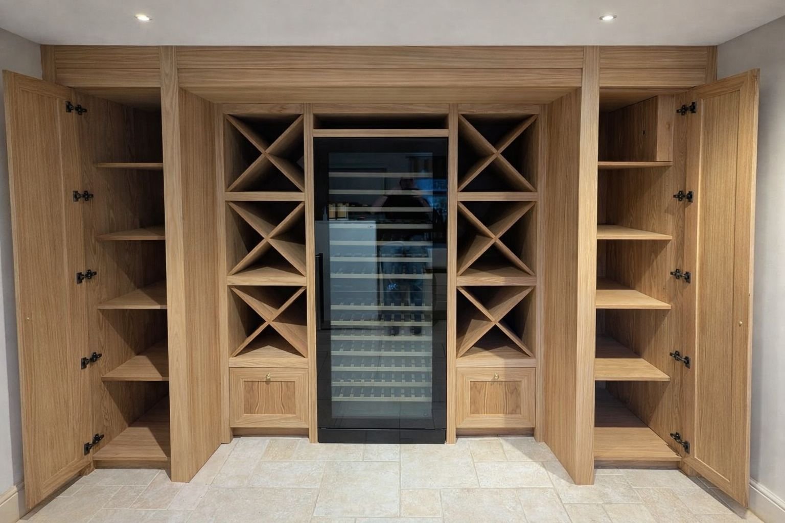 Wooden wine storage cabinets with open shelves and a glass door wine fridge in the center.