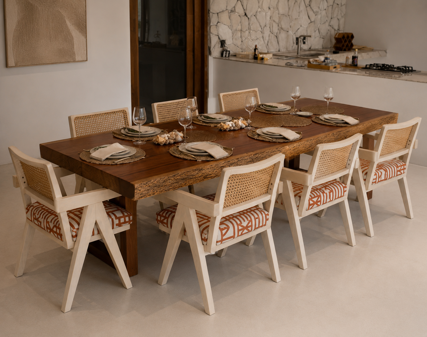 A dining table set for eight people with plates, napkins, wine glasses, and decorative centerpieces in a modern dining room.