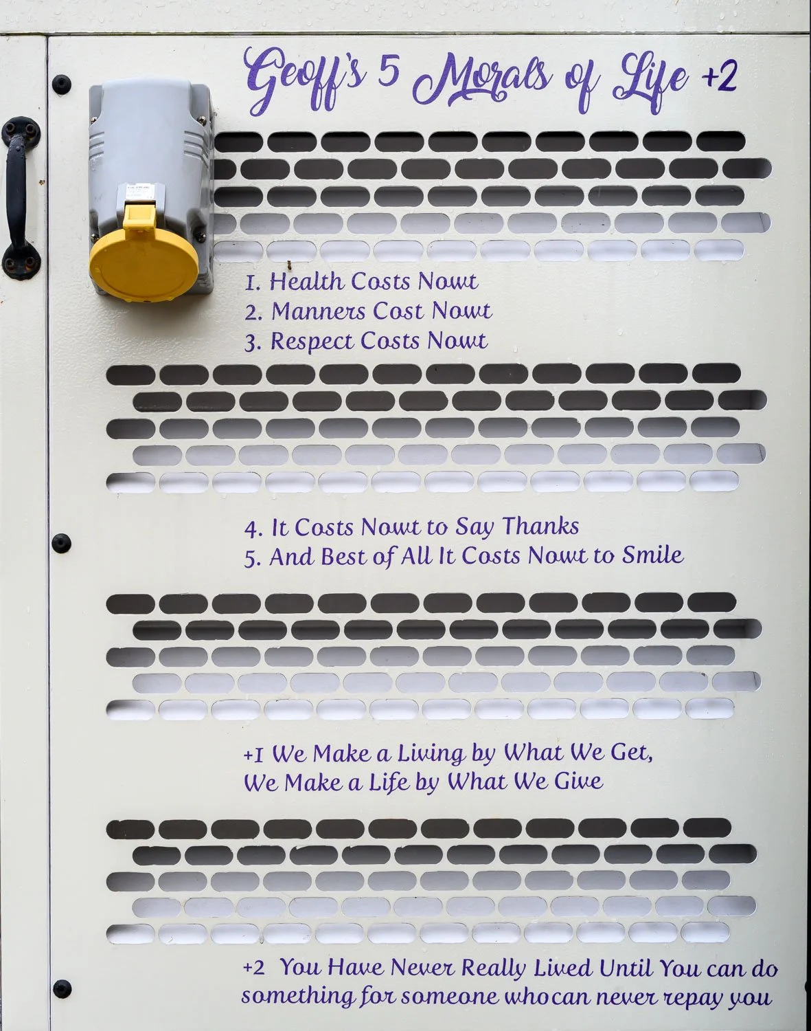 A white informational board displaying five morals of life written in purple text, with the title "Geoff's 5 Morals of Life +2" at the top. The board has a yellow and gray electrical box mounted on the left side and various ventilation slots.