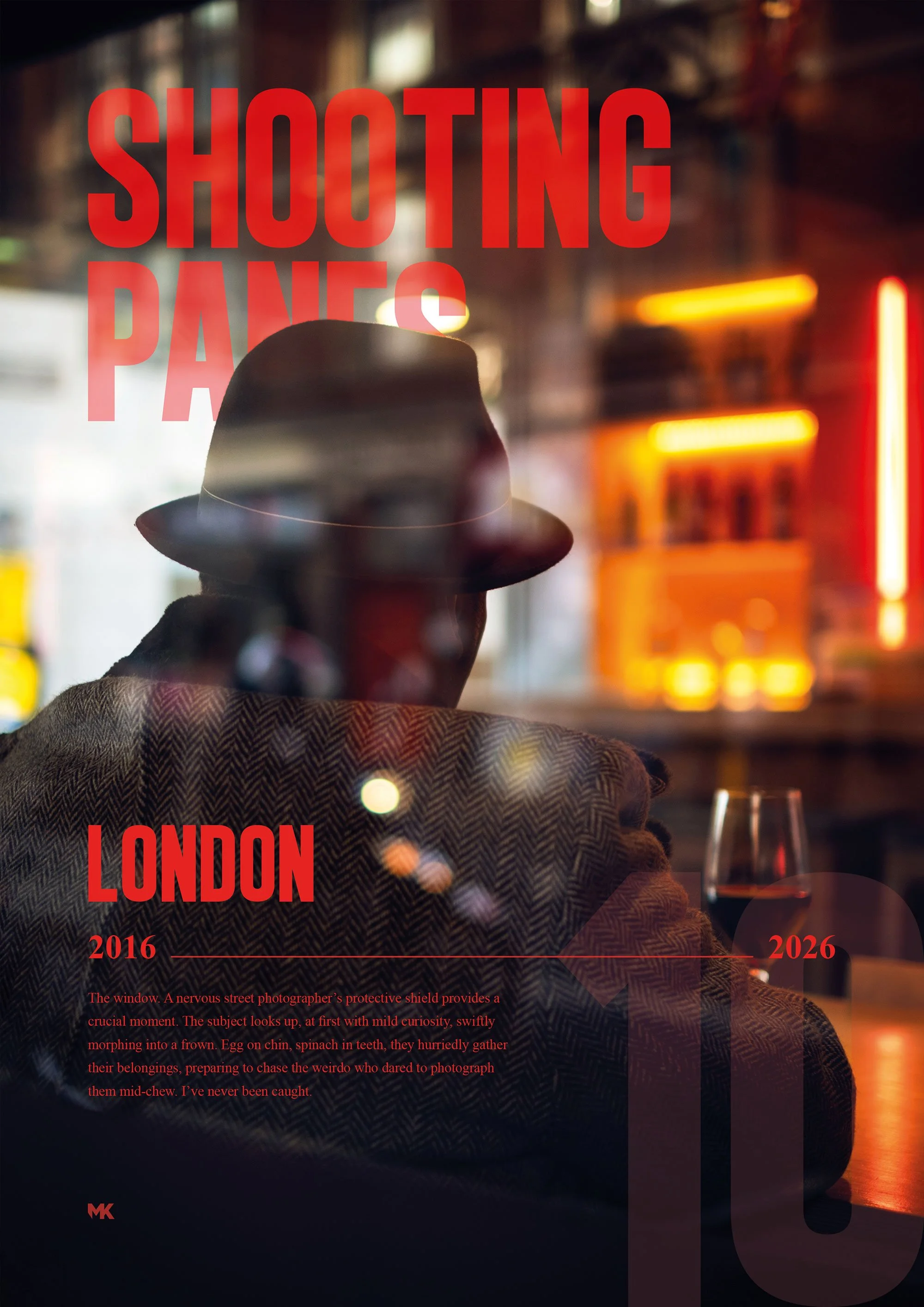 A person wearing a hat and a coat, sitting at a table with a glass of red wine, viewed through a window with red text that reads 'SHOOTING PANS LONDON 2016 - 2026'. The background features neon lights and blurred cityscape; the reflection creates a l