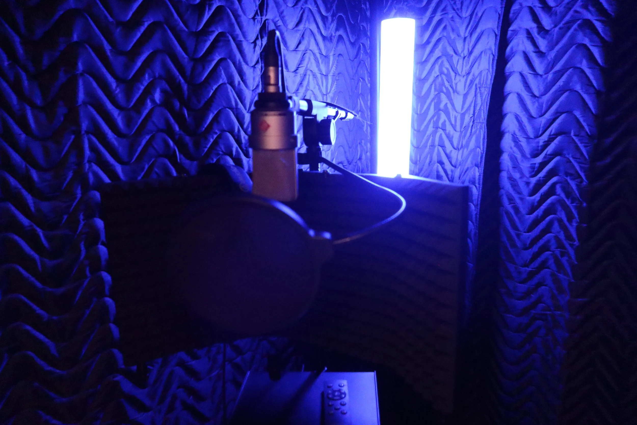 Microphone and acoustic treatment inside the blue-lit BLNDMAN Records vocal booth