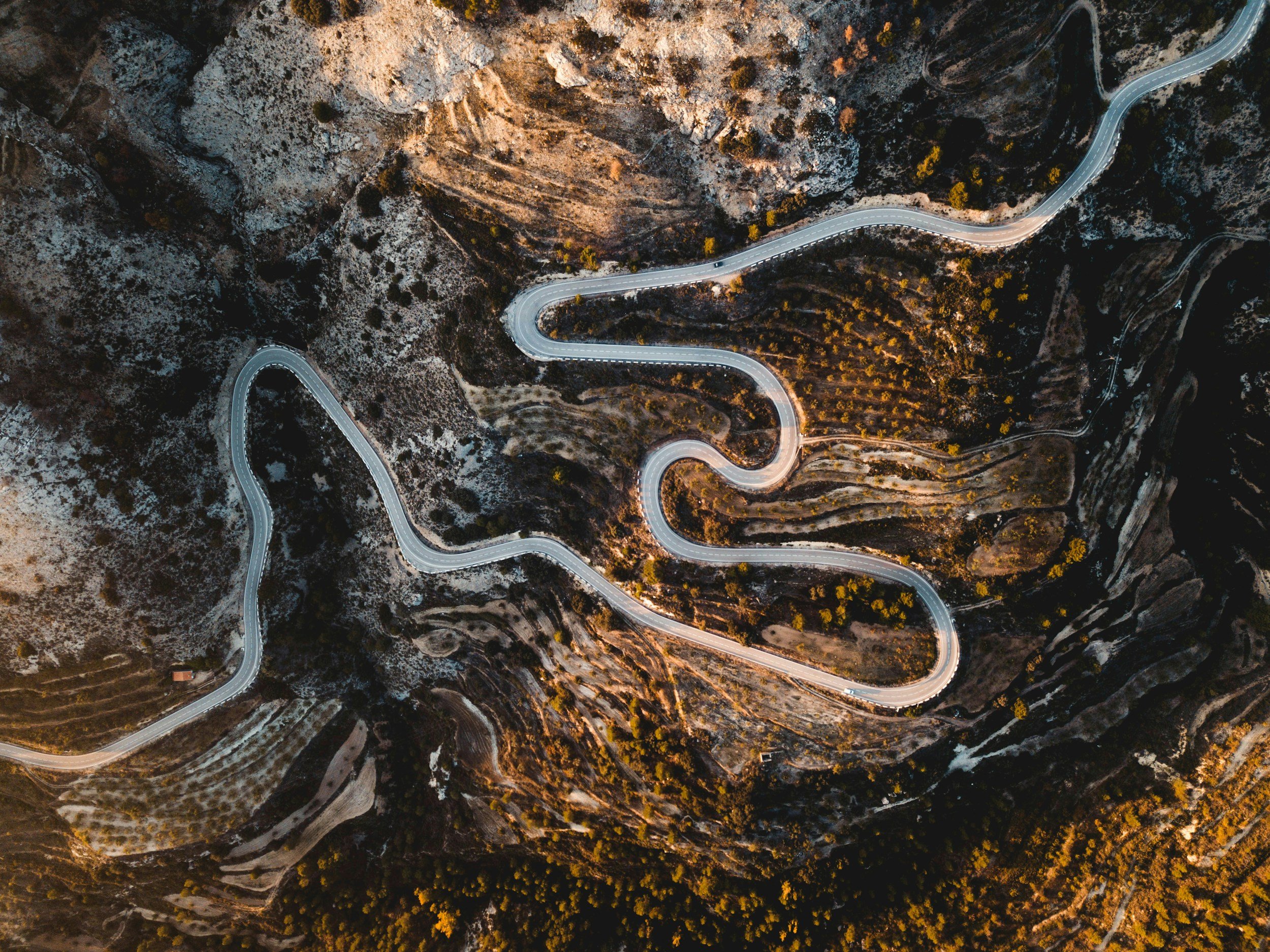 Winding road seen from above, surrounded by rocks.