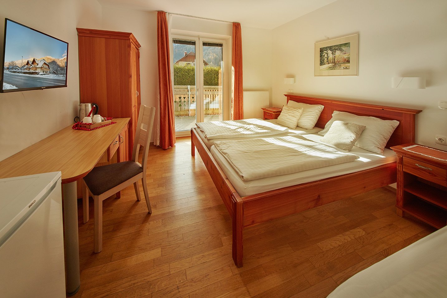 Hotel room with bed, storage wardrobe, and door to balcony
