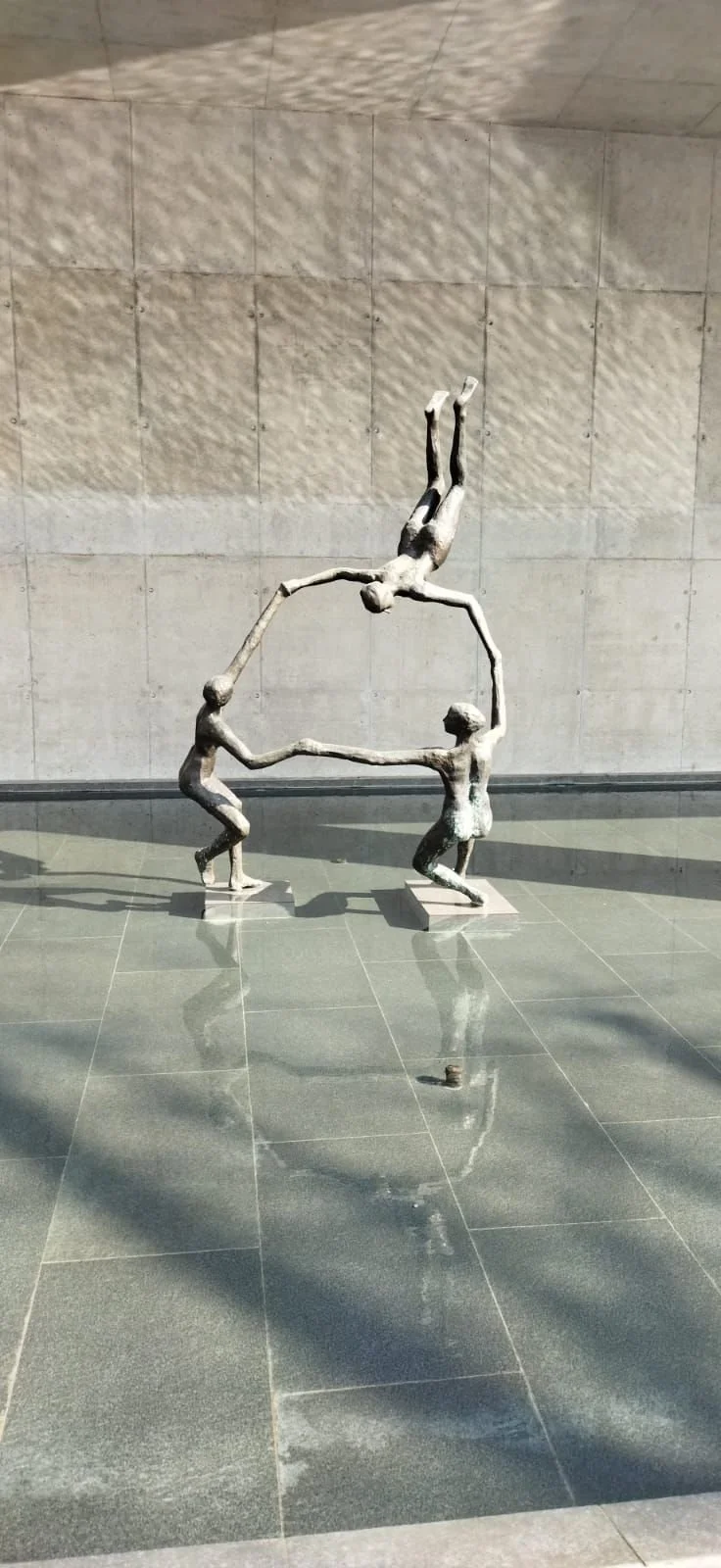 Human artwork depicting figures holding hands in a forming circle, symbolising connection, unity, and collective presence.