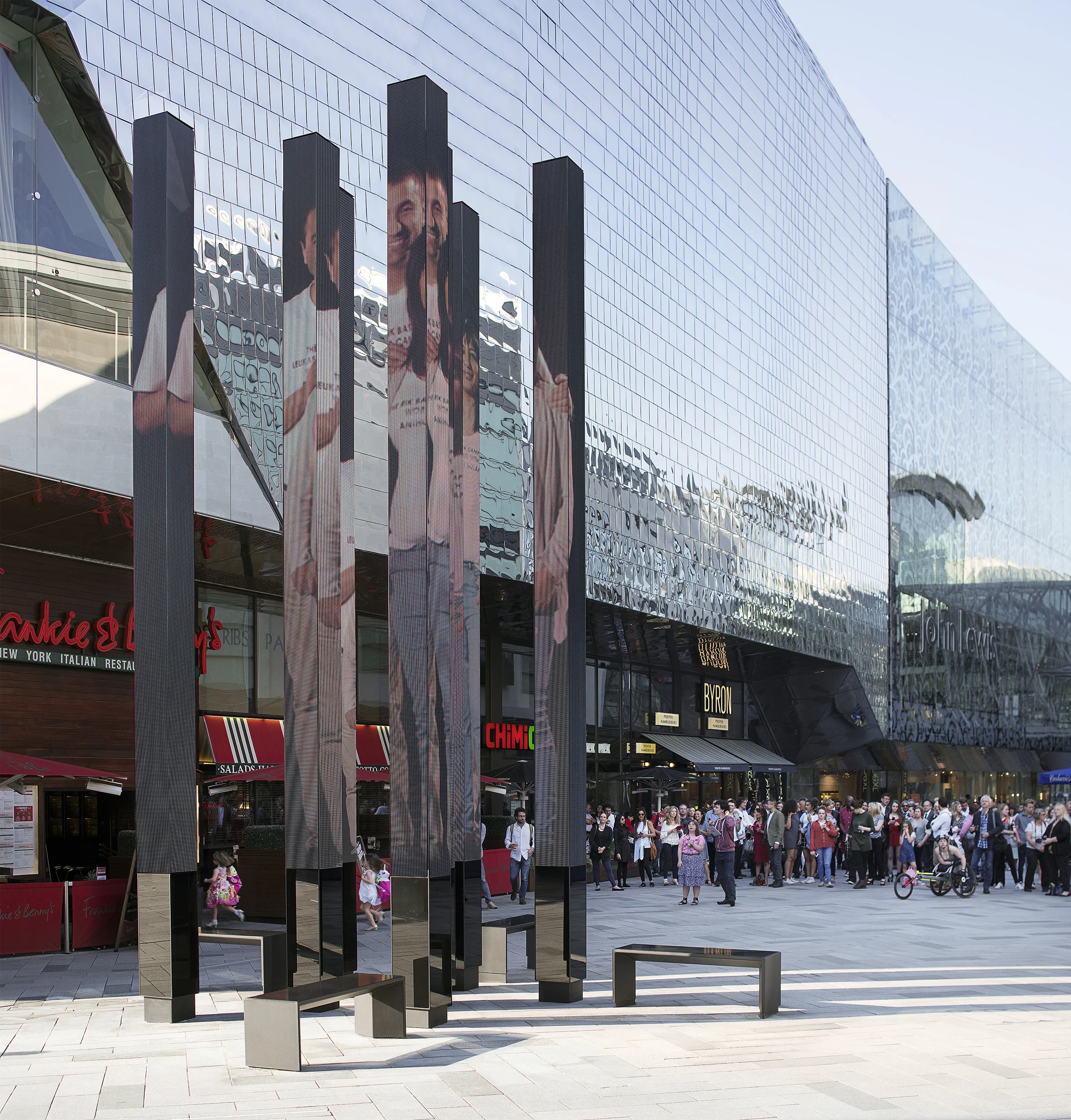 Levitate Architects Highcross Beacons Digital Sculpture displaying community digital art portraits across tall LED columns near shoppers.