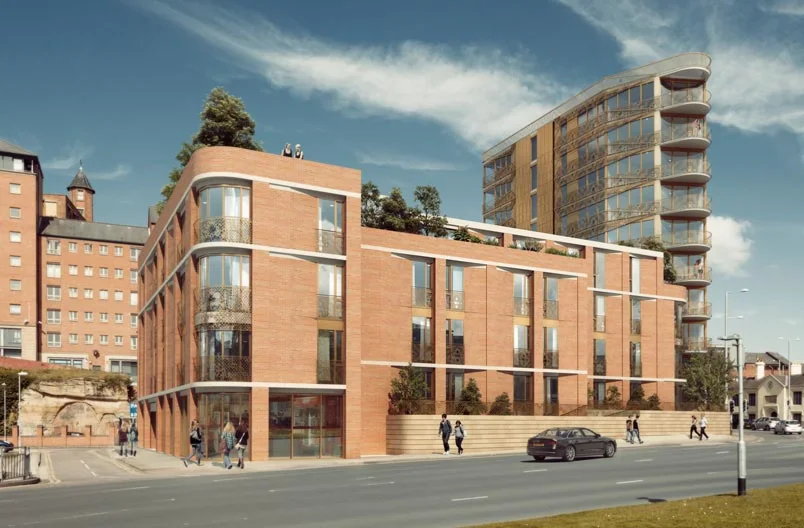 Levitate's Lace Building corner street view showing the stepped red-brick structure with decorative metal railings and green roof terraces