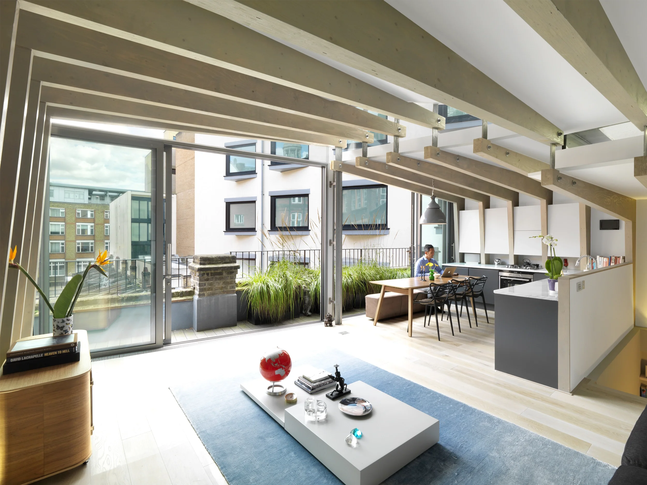 Levitate's London Shoreditch Loft living space with exposed timber frames and glazed clerestory windows above a black sofa