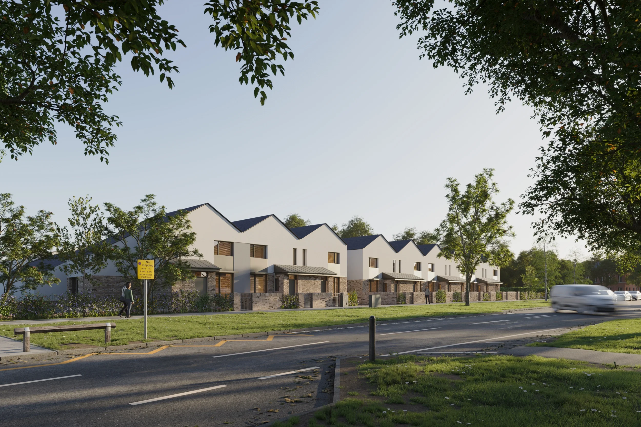 Levitate Architects FLEC Leicester modern housing development view with pitched roofs, brick ground floor, and white upper walls along a main road.