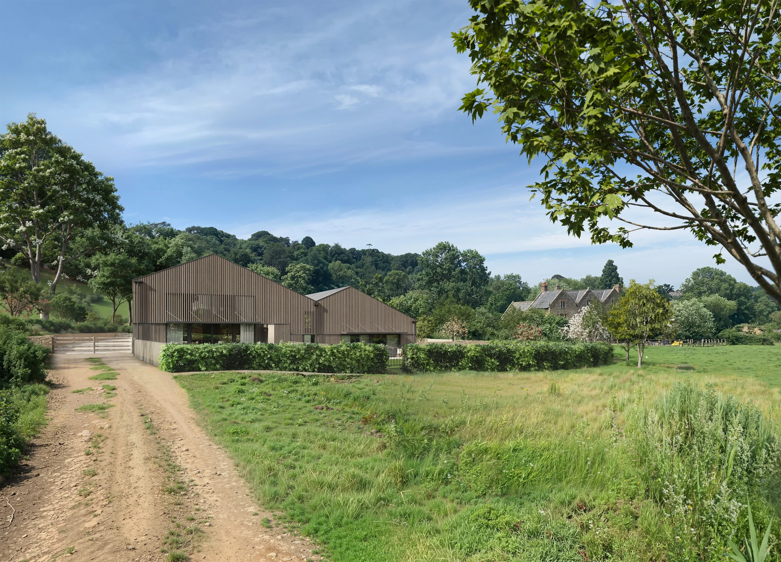 Levitate's Newton Farm Barns exterior view from the access track showing modern timber-clad conversions alongside the Grade II listed farmstead