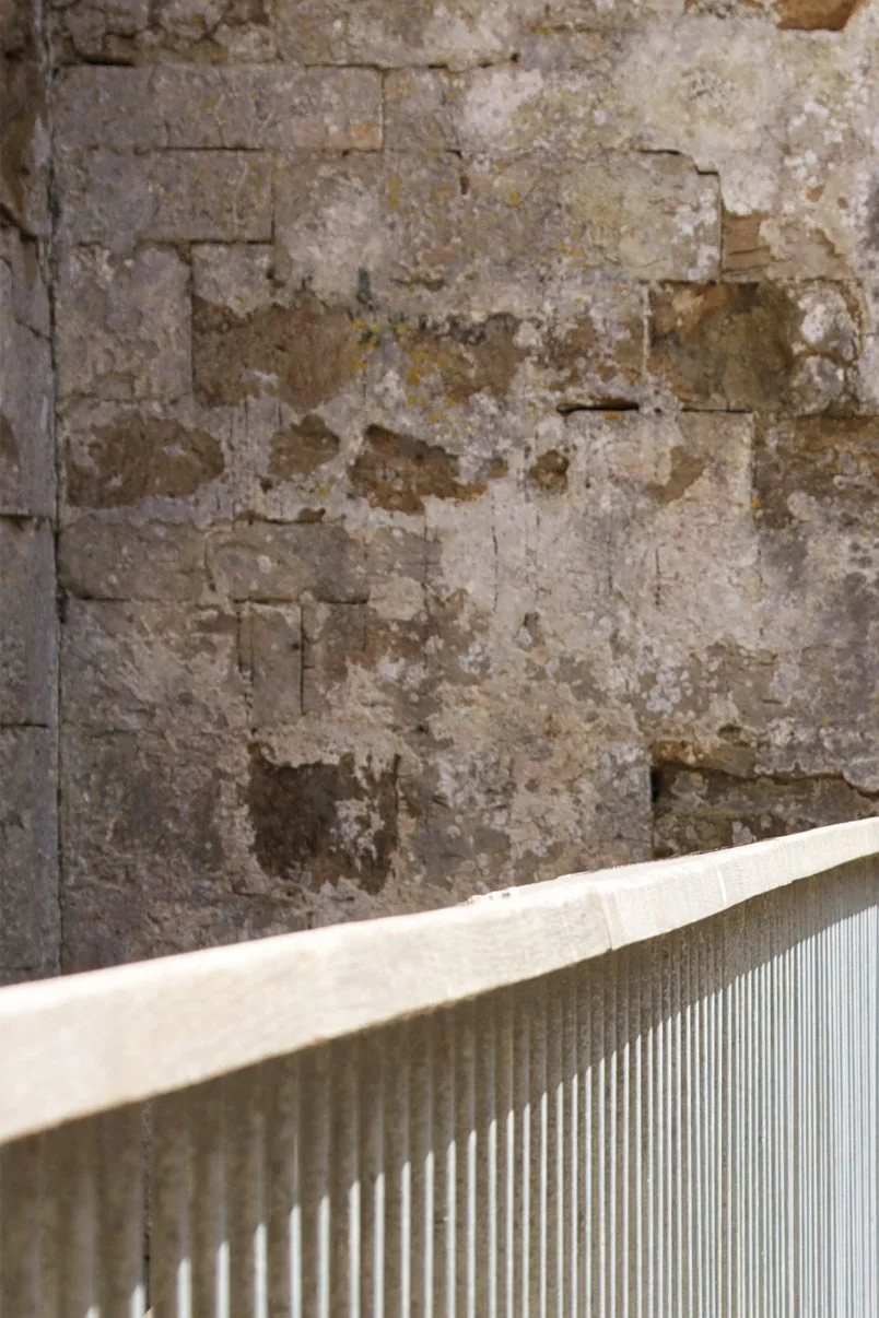Award Winning Levitate Architects' Sandsfoot detail pairs a sleek wooden handrail with weathered heritage stone, uniting old and new.