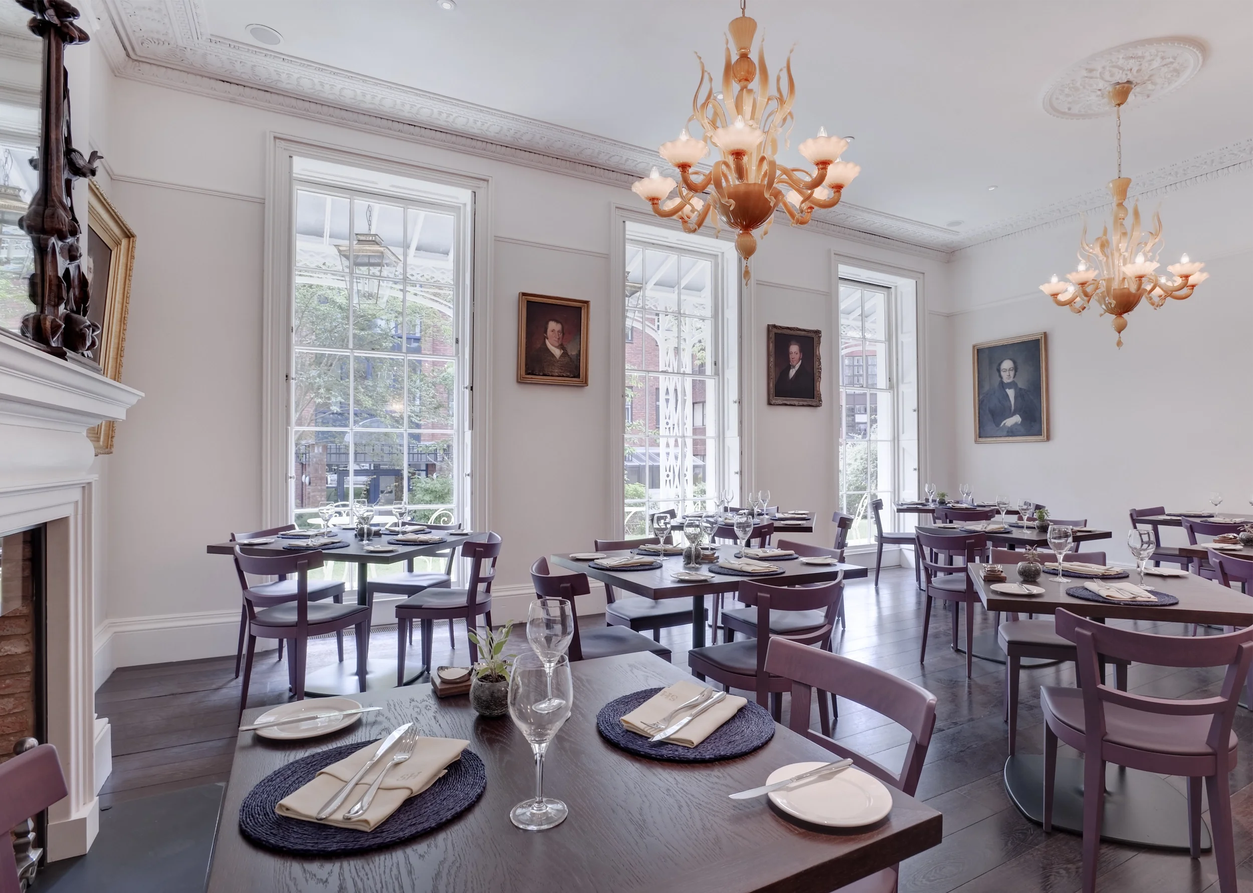 Levitate's Southernhay Hotel dining room with tall sash windows, antique portraits and ornate glass chandeliers