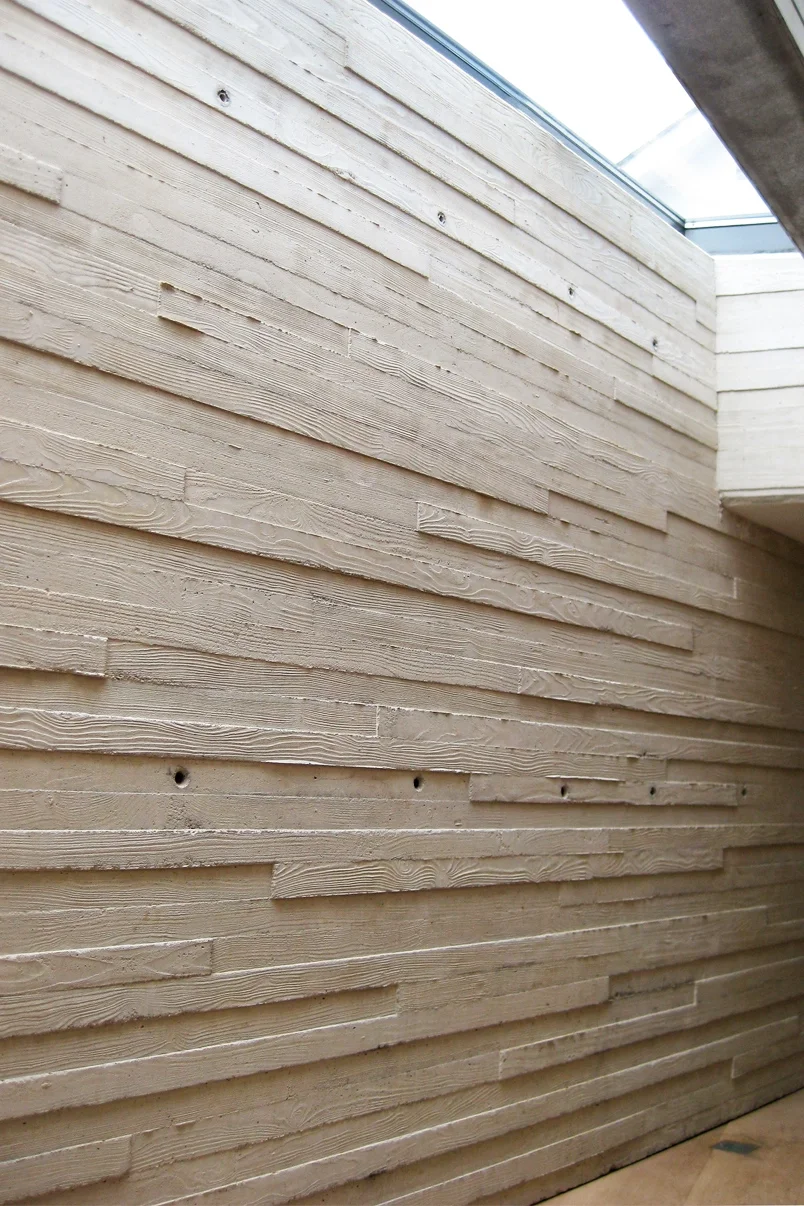 Levitate Architects Torhill Farm heritage detail showing board‑formed concrete wall with timber grain texture and skylight bringing natural light inside.