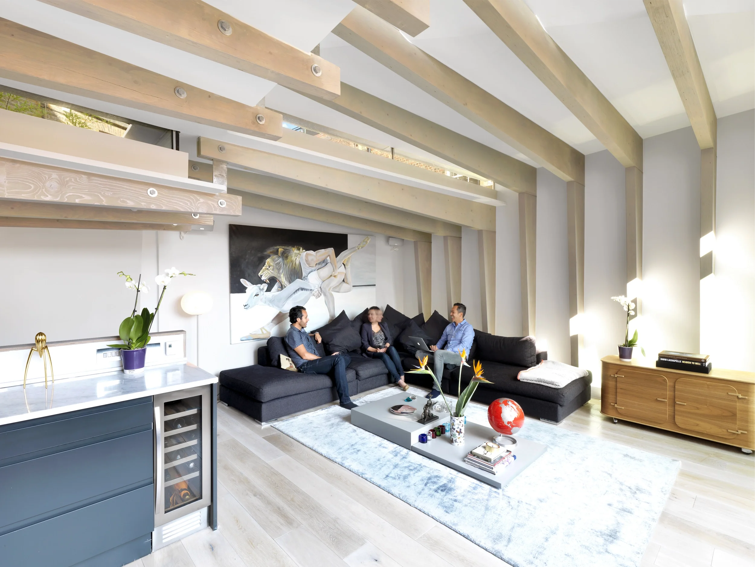 Levitate's London Shoreditch Loft living space with exposed timber frames and glazed clerestory windows above a black sofa