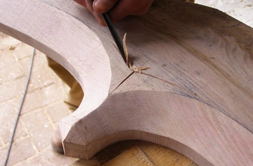 Levitate Architects' Whitestaunton Manor close-up captures expert heritage craftsmanship as a specialist carves timber for property conservation.