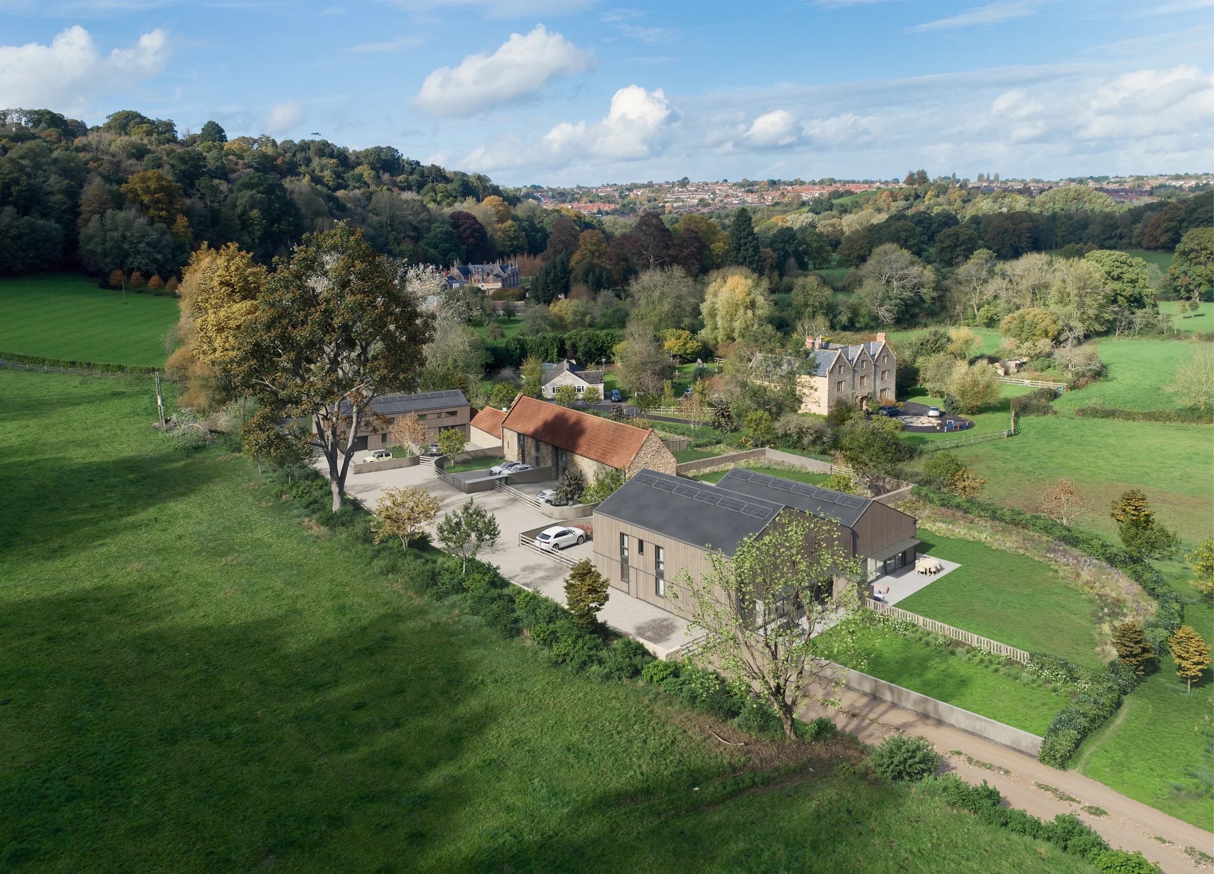 Levitate's Newton Farm Barns aerial site overview showing the restored Grade II listed stone barn and timber-clad homes surrounded by fields