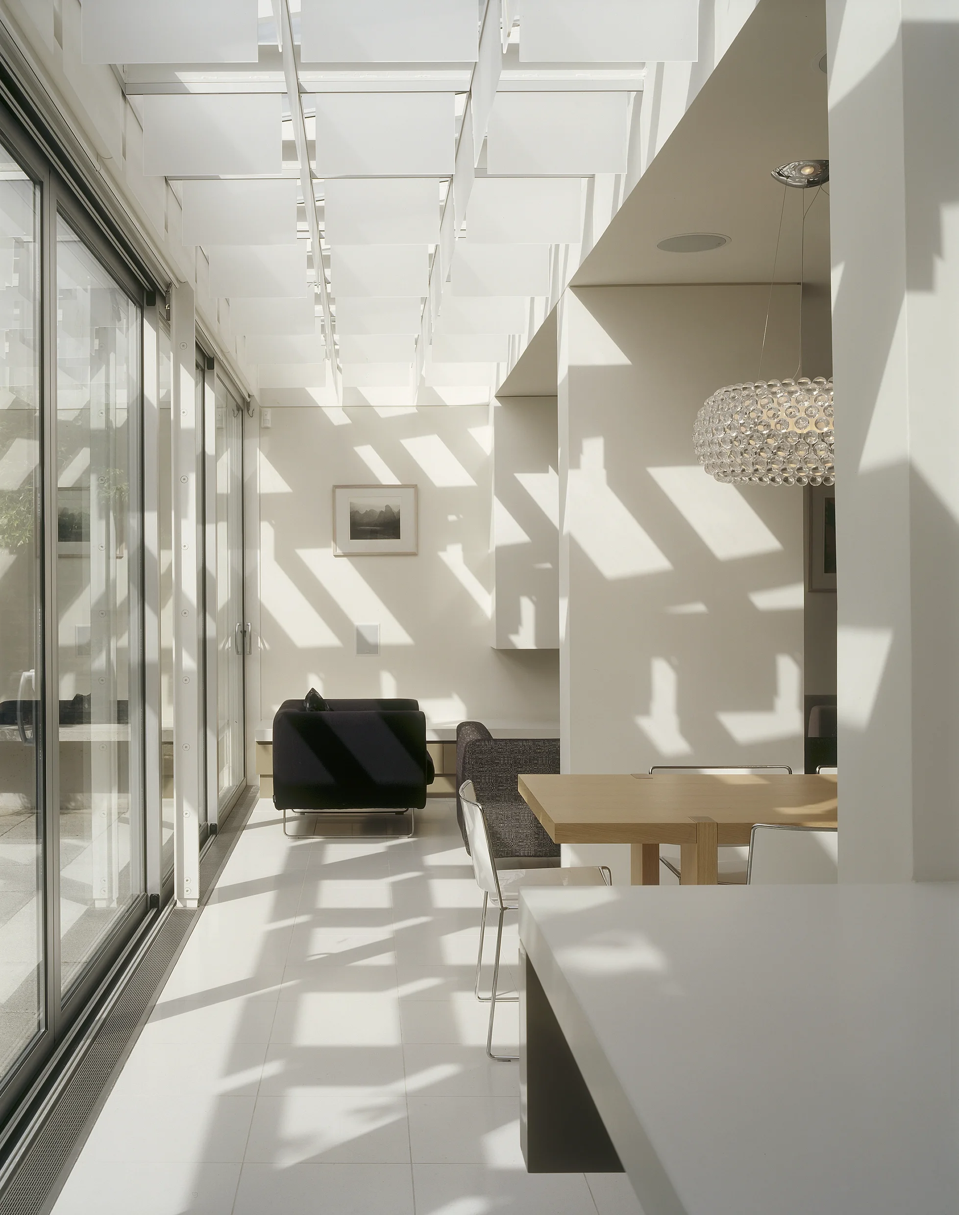 Levitate's wandsworth house, dapples of sunlight create dramatic patterns on the white floor of this modern home extension.