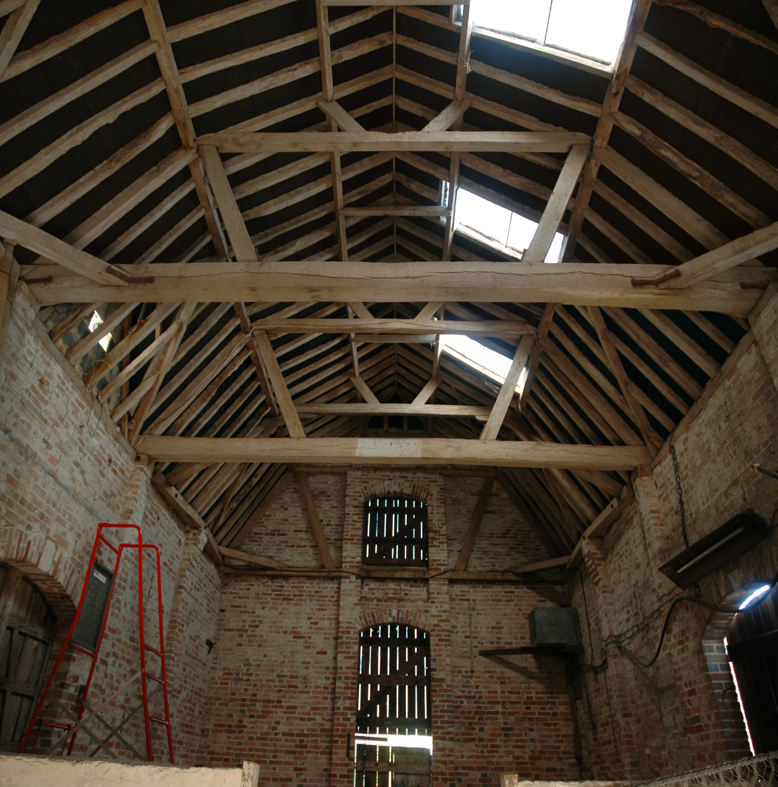 Levitate's Ersham Farm existing barn interior showing exposed oak roof trusses and original brick walls before conversion