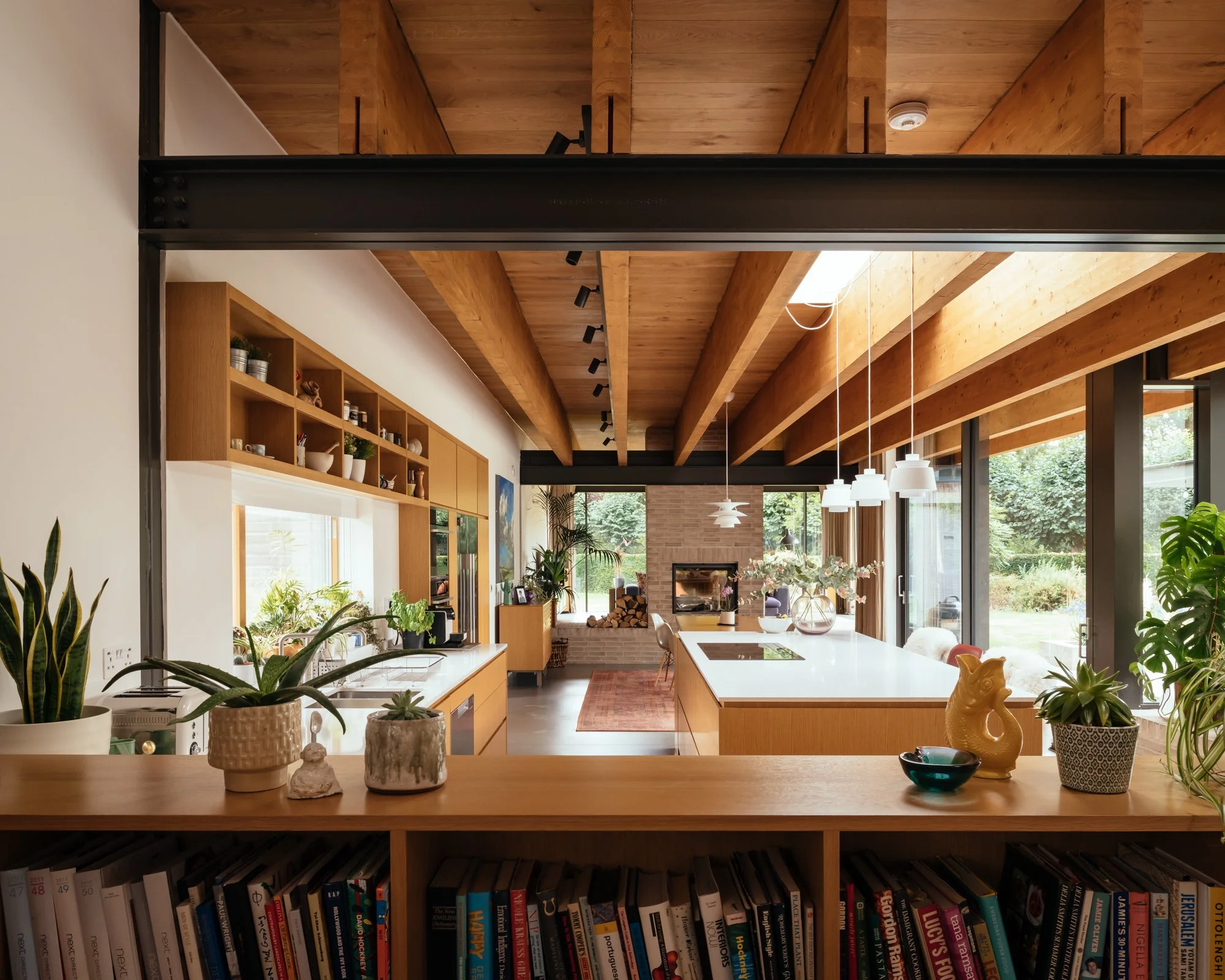 Levitate's award winning Maple Lodge utilises crafted mid-century modern inspired sustainable home, viewed overlooking the kitchen with exposed glulam beams and metal structure light filled by large glazing.