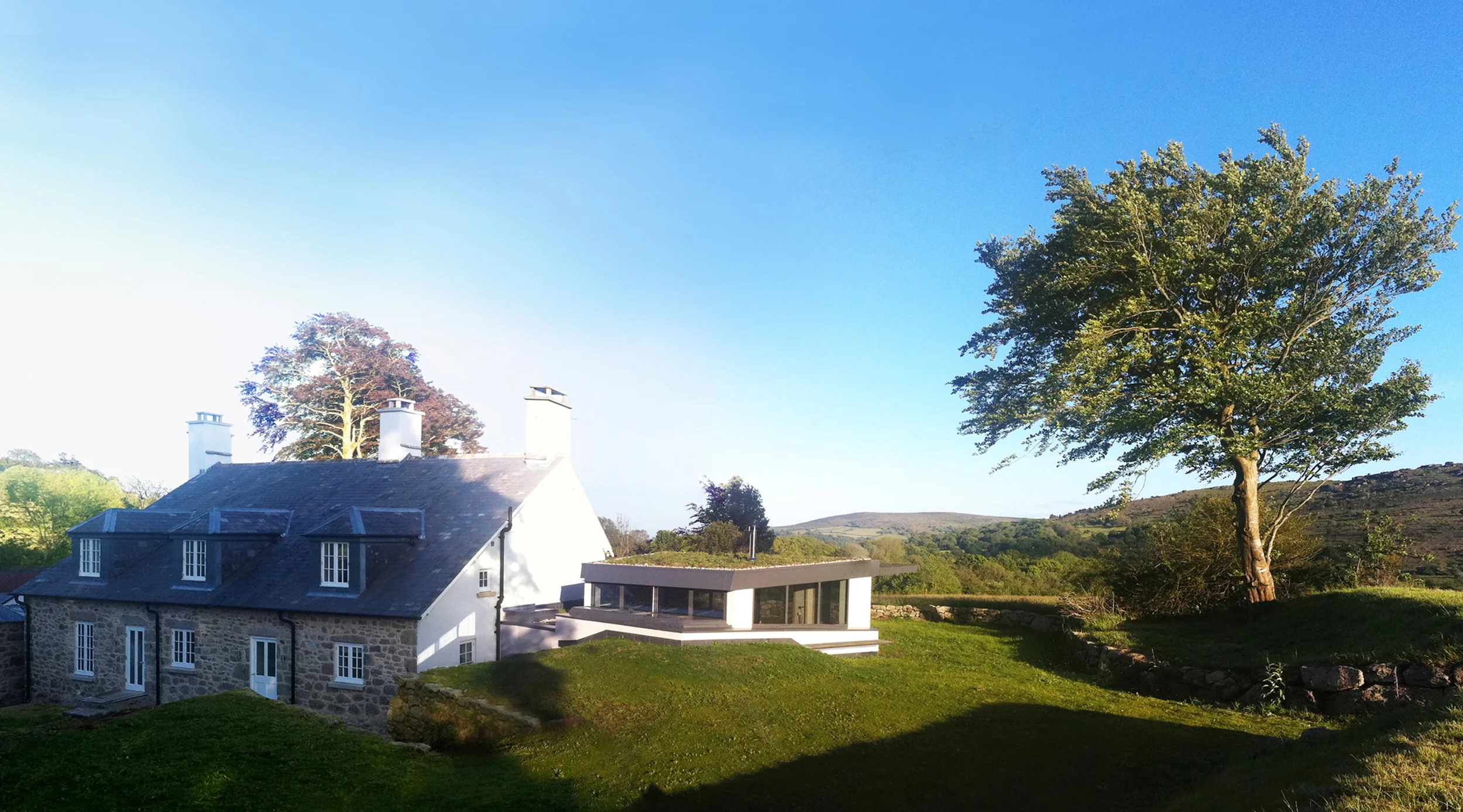 Levitate Architects Torhill Farm heritage renovation combining traditional stone farmhouse with modern extension overlooking Dartmoor countryside.