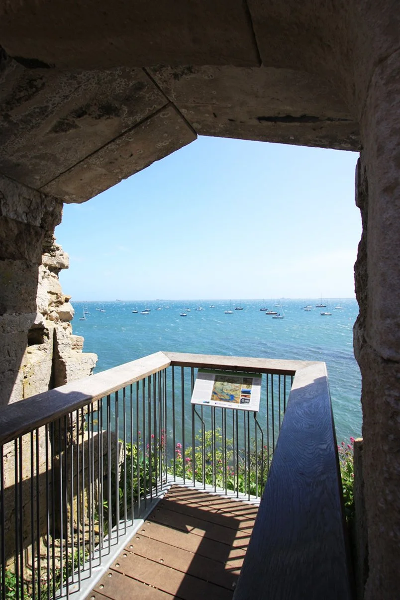 Award Winning Levitate Architects' Sandsfoot archway frames a modern viewing balcony, blending heritage stone with a scenic sea view.