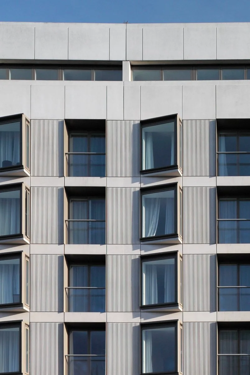 Architectural detail of the concrete facade at Nottingham One by Levitate Architects, featuring recessed windows and textured vertical ribbing.