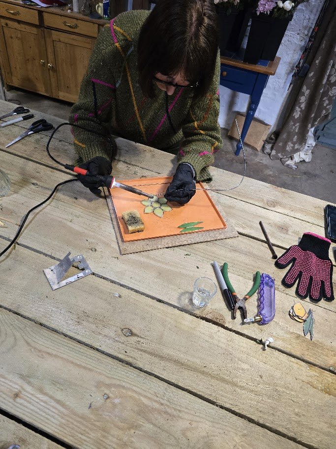 A student learning a new skill while using a soldering iron