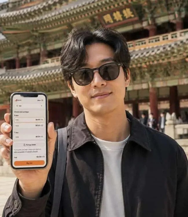 A traveler holding an iPhone displaying an active Airalo eSIM network profile in South Korea