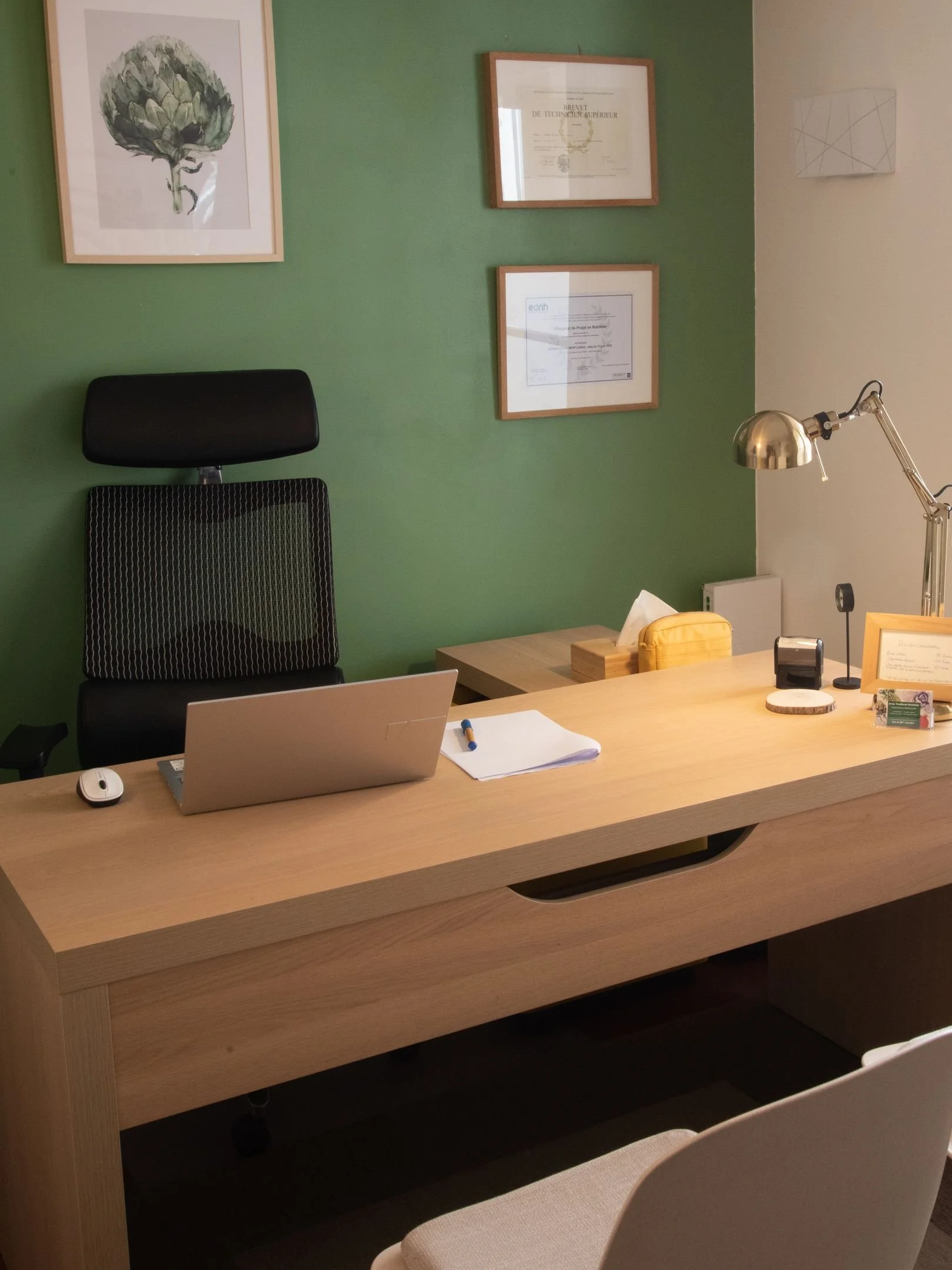 Bureau du cabinet de Maisons-Laffitte : ordinateur, papiers, certificats et illustration d'artichaut.