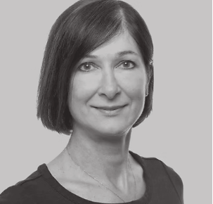 Black and white portrait of a woman with straight, shoulder-length hair, wearing a dark top, looking at the camera.
