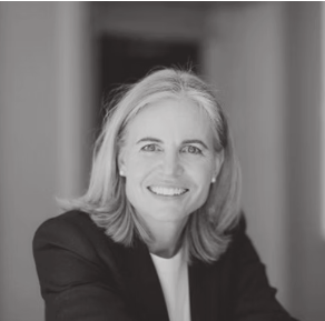 Black and white portrait of a woman with shoulder-length hair and a blazer, smiling at the camera.