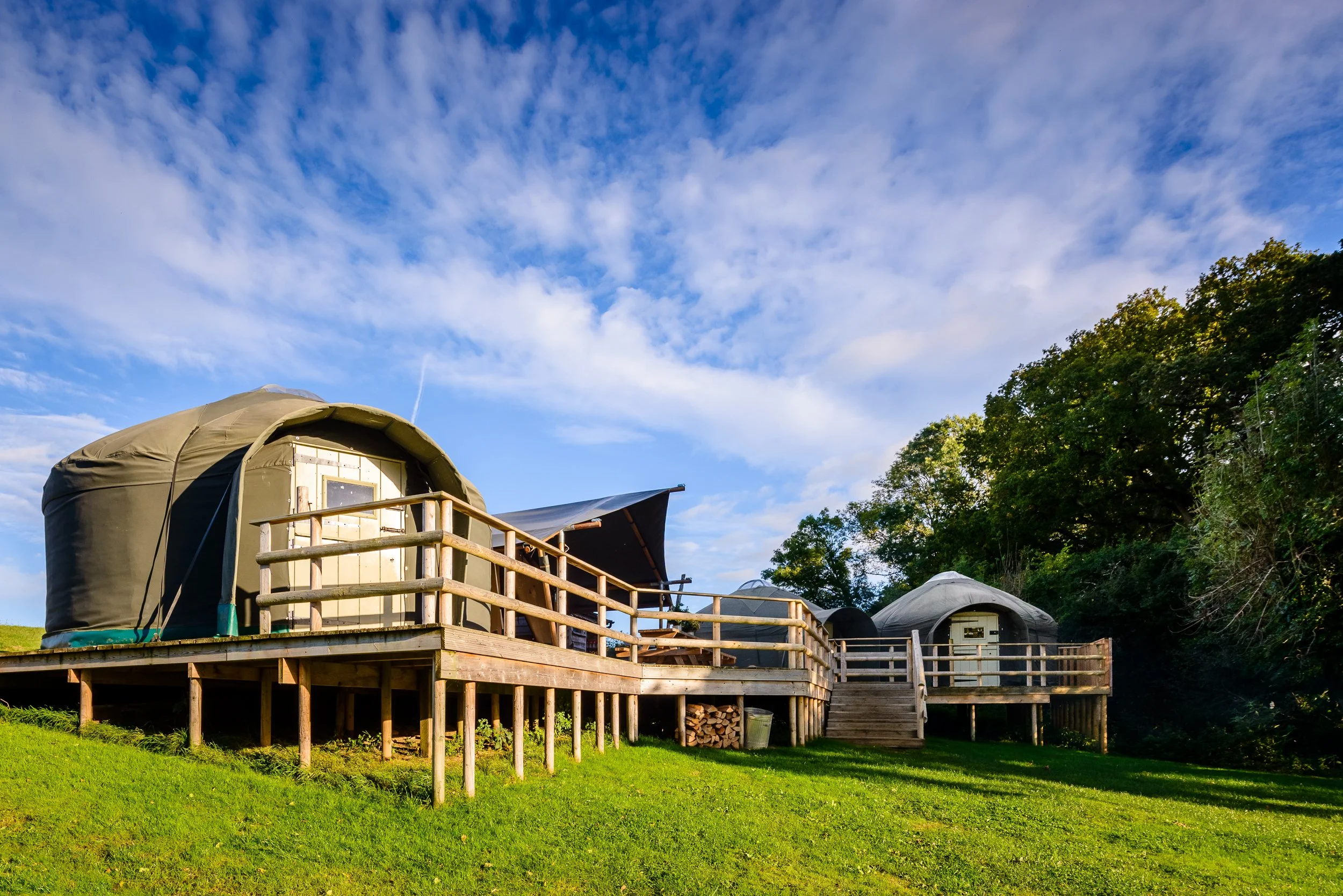 Safari tent accommodation at Stock Gaylard, photographed from the exterior with outdoor seating and surrounding countryside.