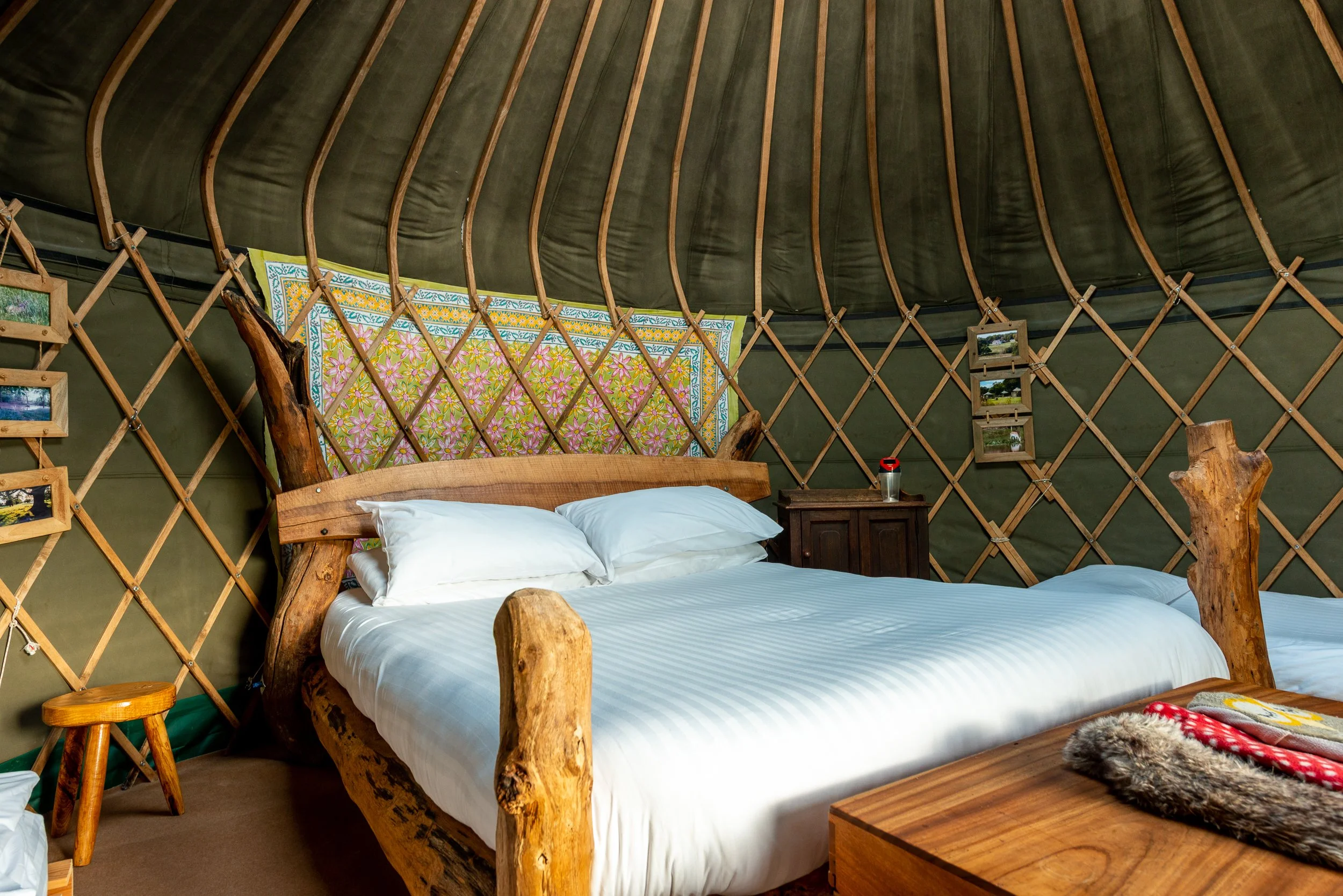 Bedroom area inside a glamping tent at Stock Gaylard, showing a double bed, timber structure and soft furnishings.