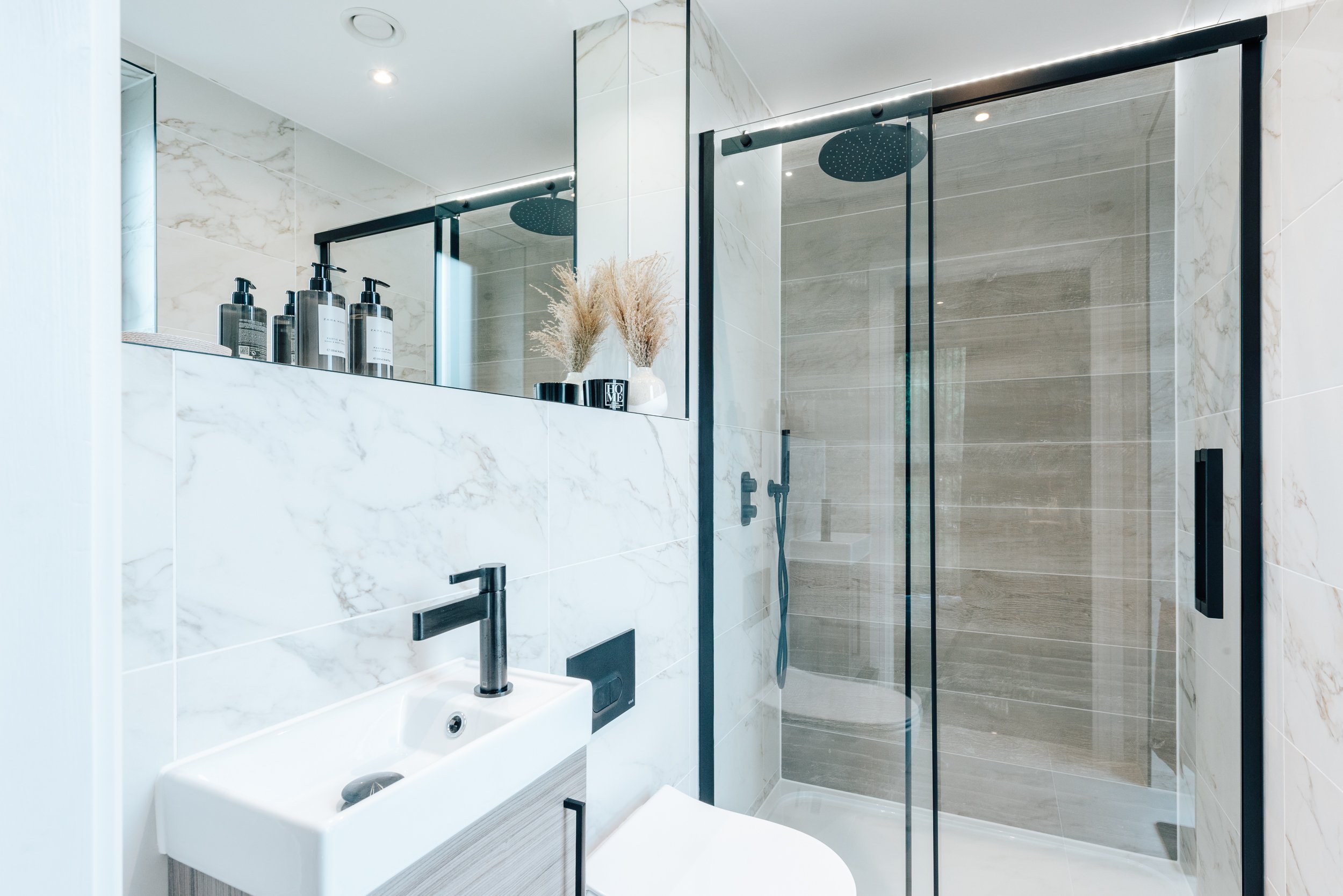 Modern bathroom with walk-in shower, floating vanity unit, large-format wall tiles and contemporary fittings.