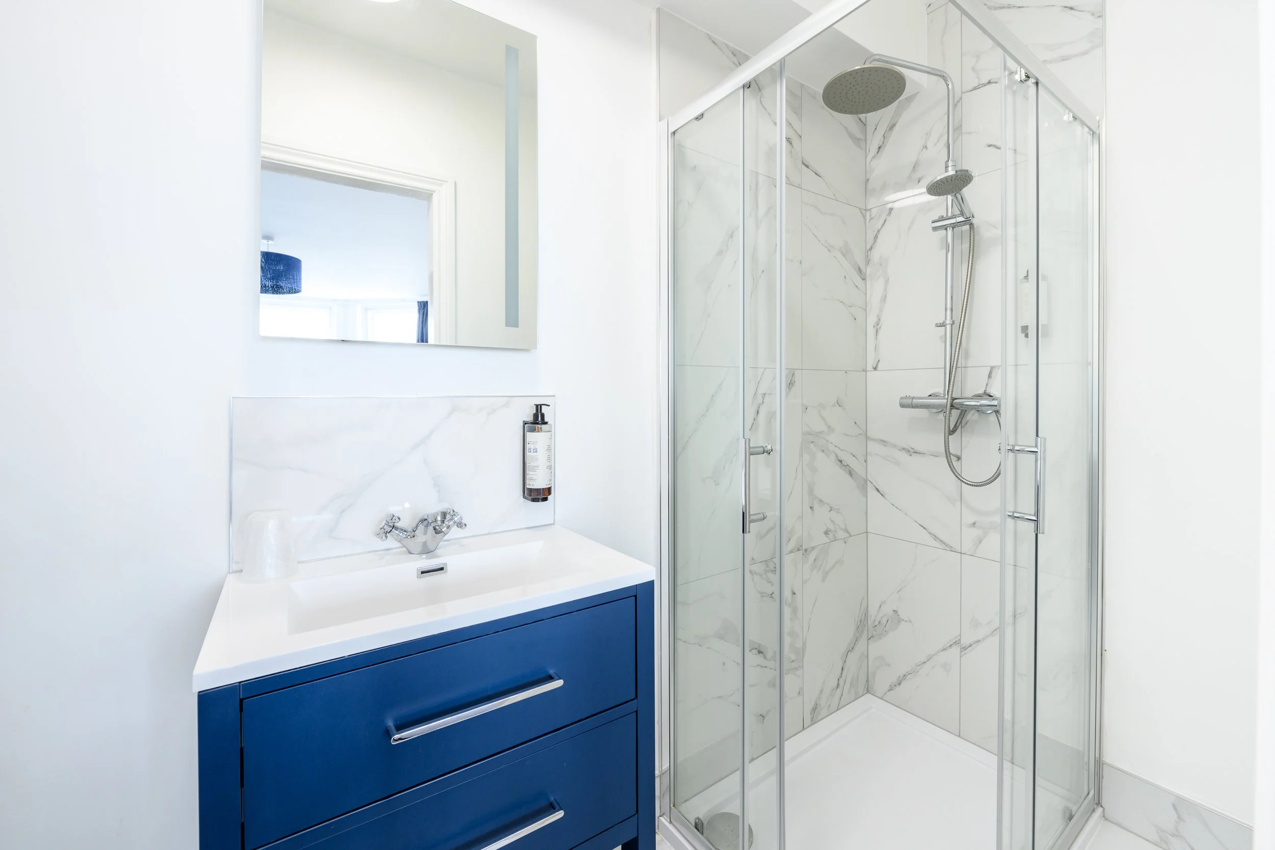 Modern ensuite bathroom with walk-in shower and vanity unit at the Esplanade Hotel.