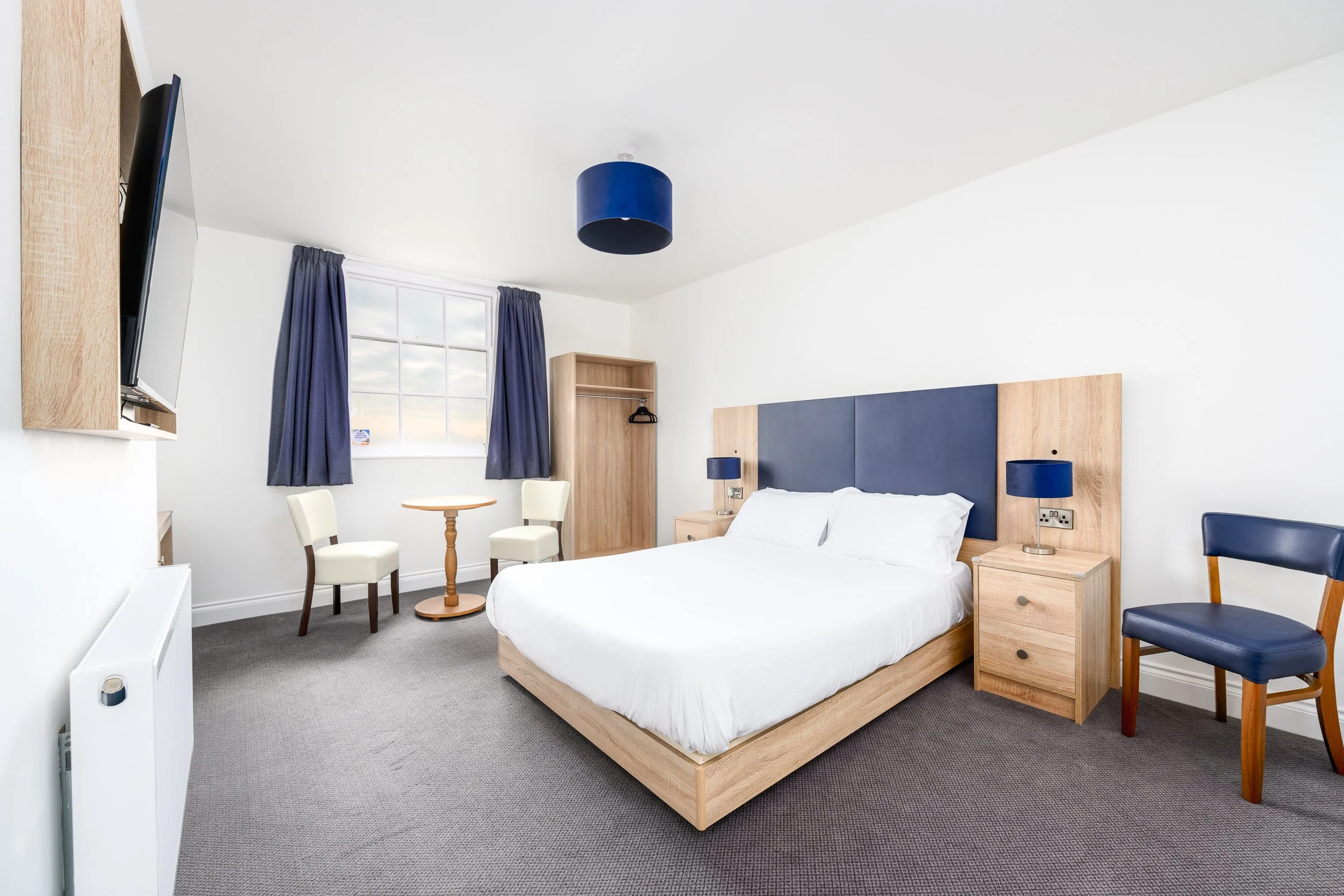 Double guest bedroom at the Esplanade Hotel featuring contemporary furnishings and natural daylight.