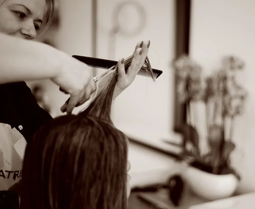 A hairdresser cutting a client's hair with scissors at Albert Fields Hair Salon in Berkshire